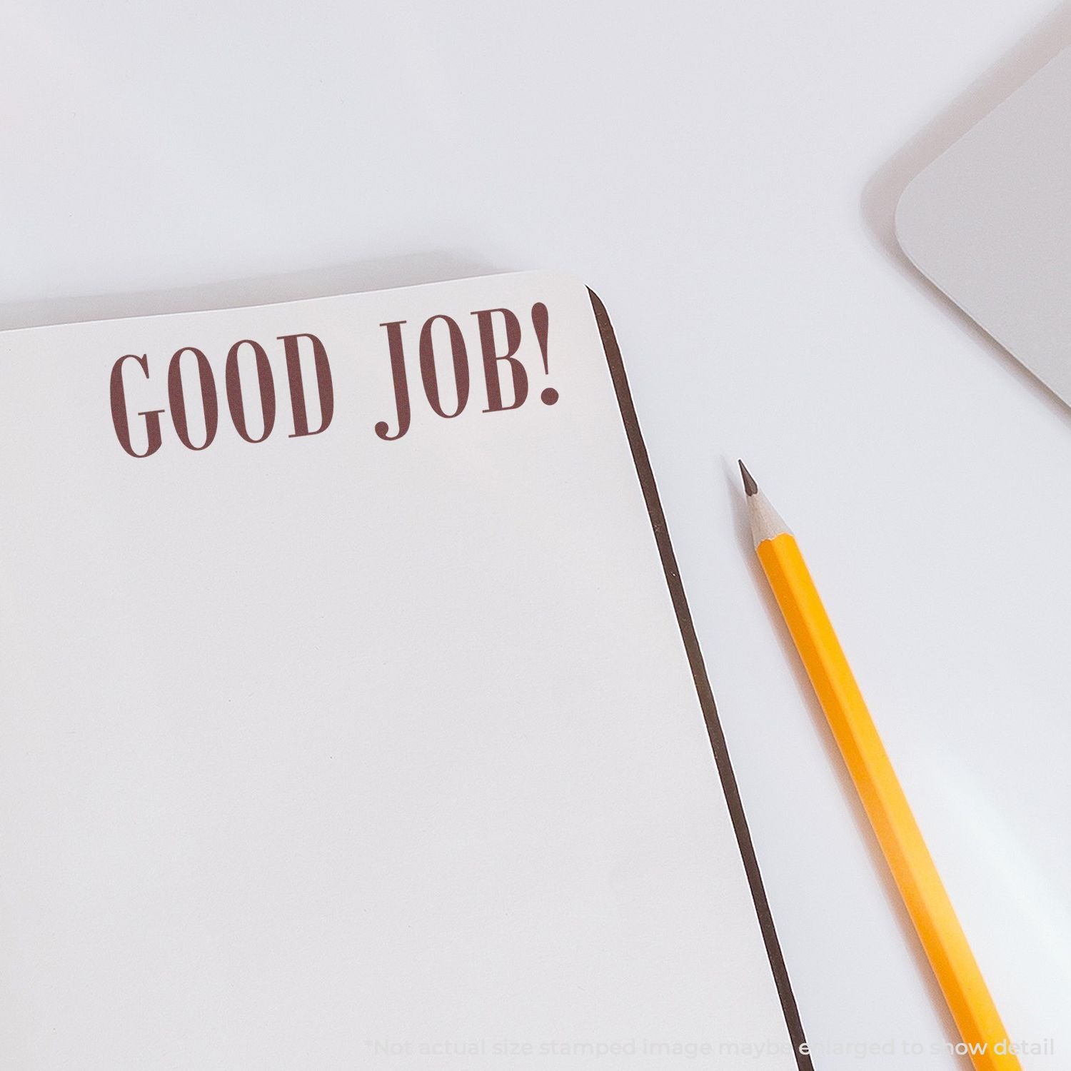Notebook page reading GOOD JOB! with a pencil, conveying positive achievement feedback for school or work.