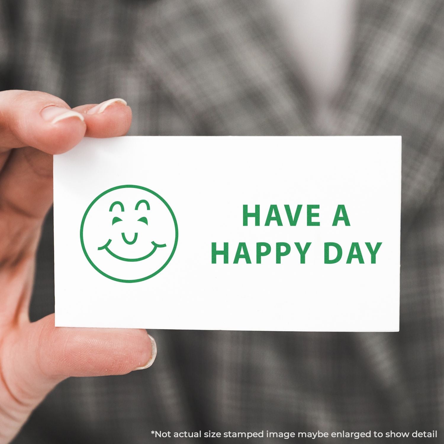 Hand holding a greeting card with green smiley and Have a Happy Day message for cheerful daily encouragement