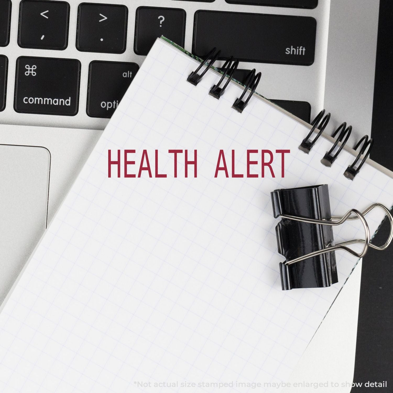 Health alert notebook with stethoscope on computer keyboard, showing online health monitoring and medical warning message for users.