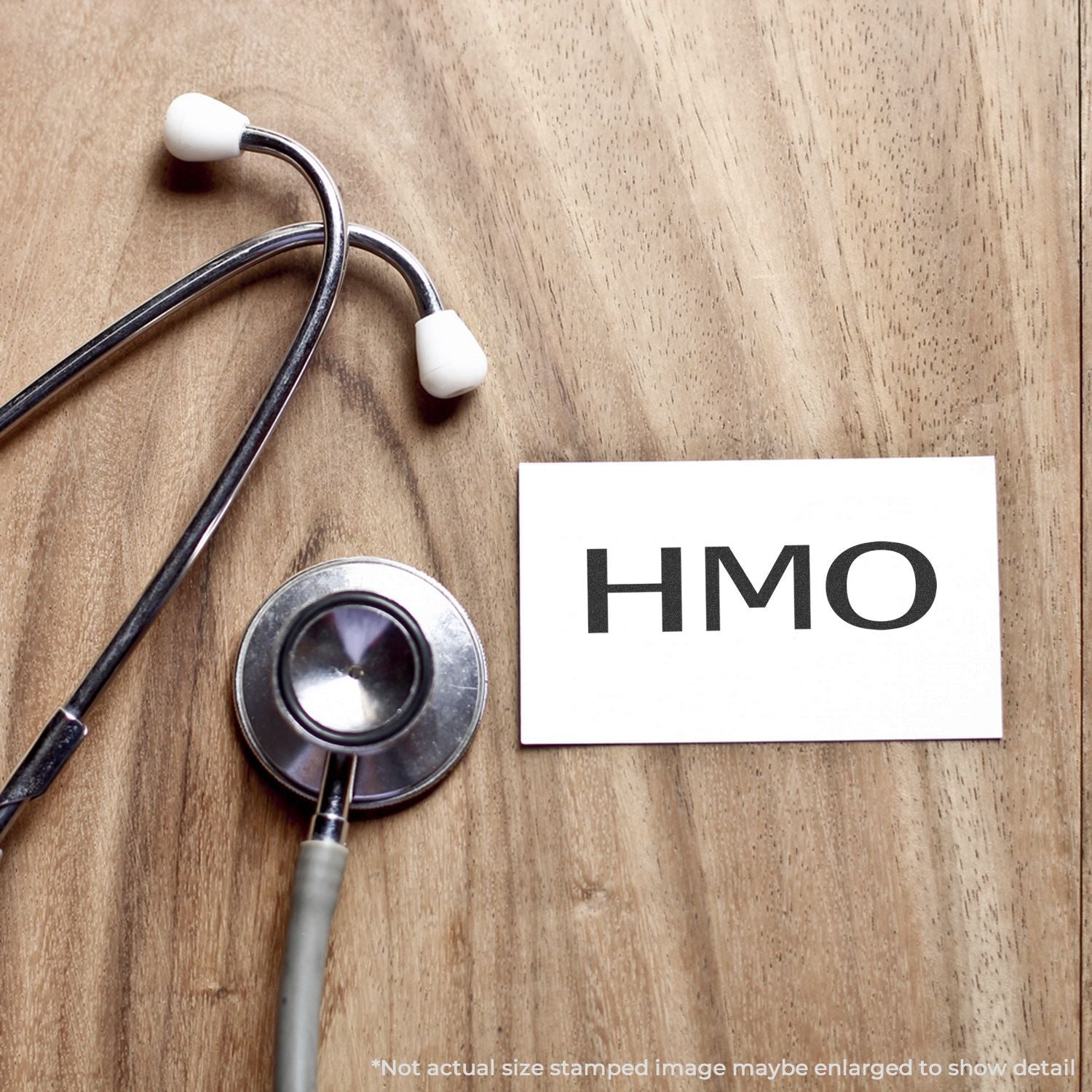 Stethoscope beside an HMO card on a wooden desk, highlighting managed care health insurance plans and primary care coverage.