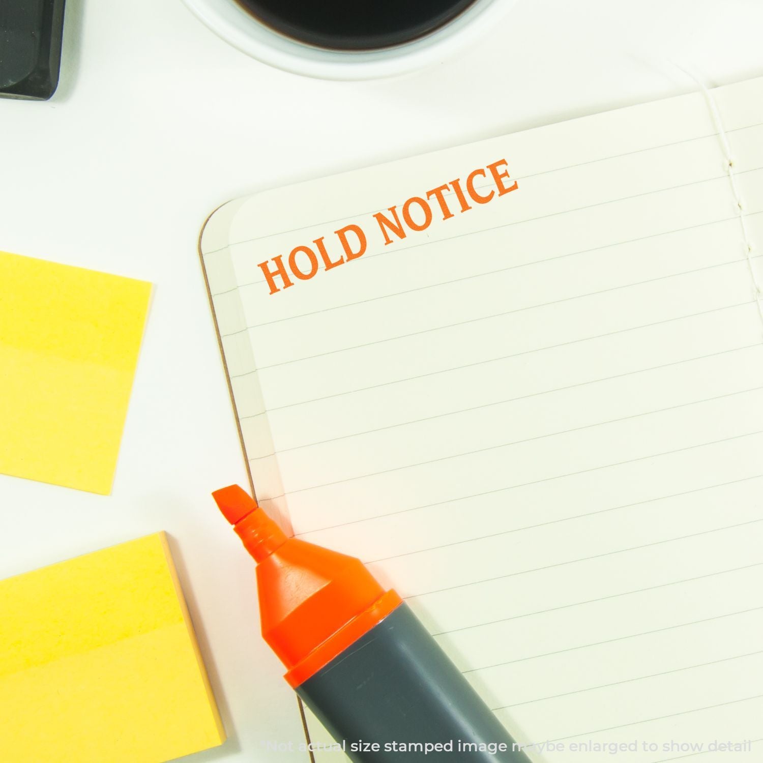 Hold notice stamp on notebook page with pen and sticky notes, illustrating document hold notification process.