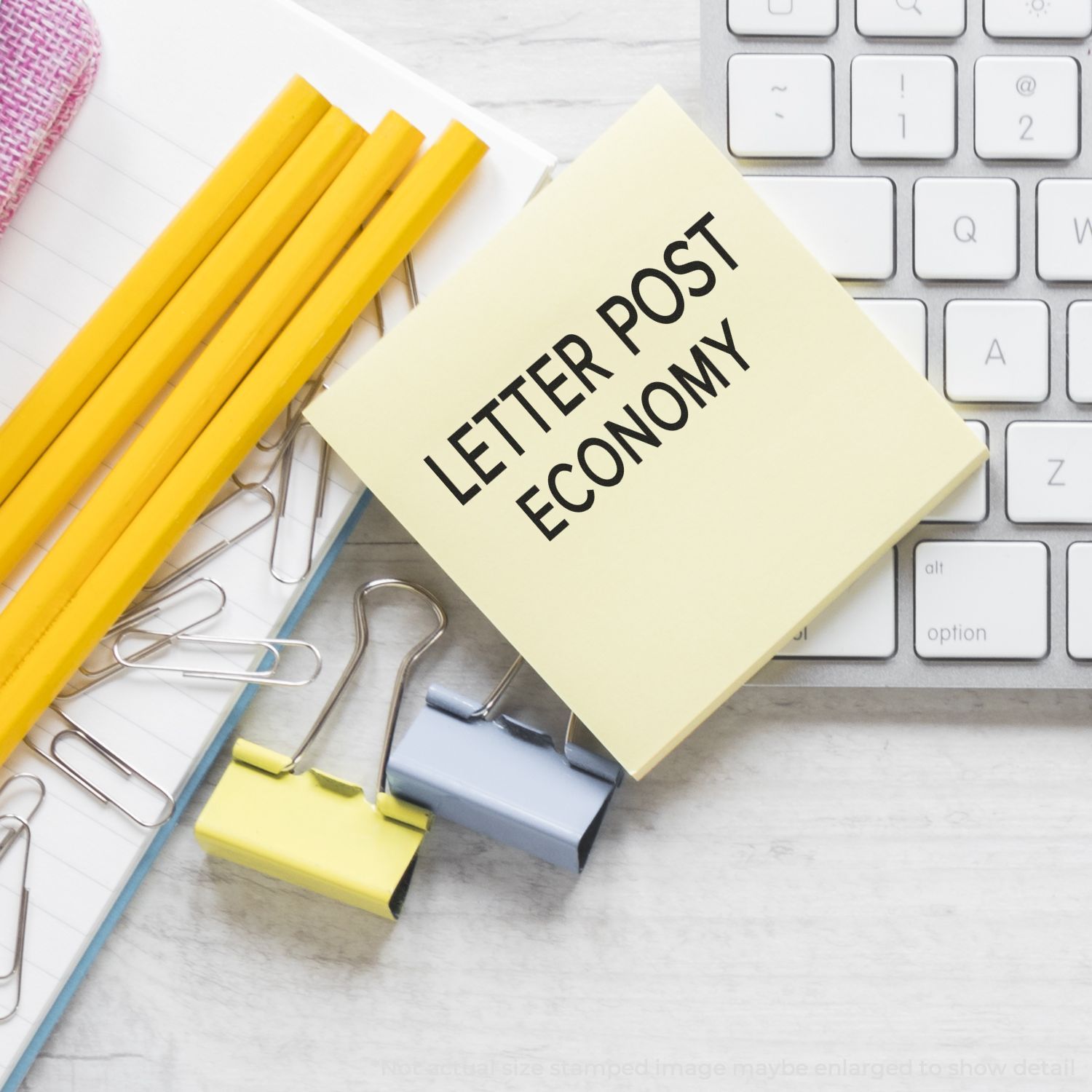 Letter post economy note on computer keyboard with stationery and paper clips, office mailing concept.