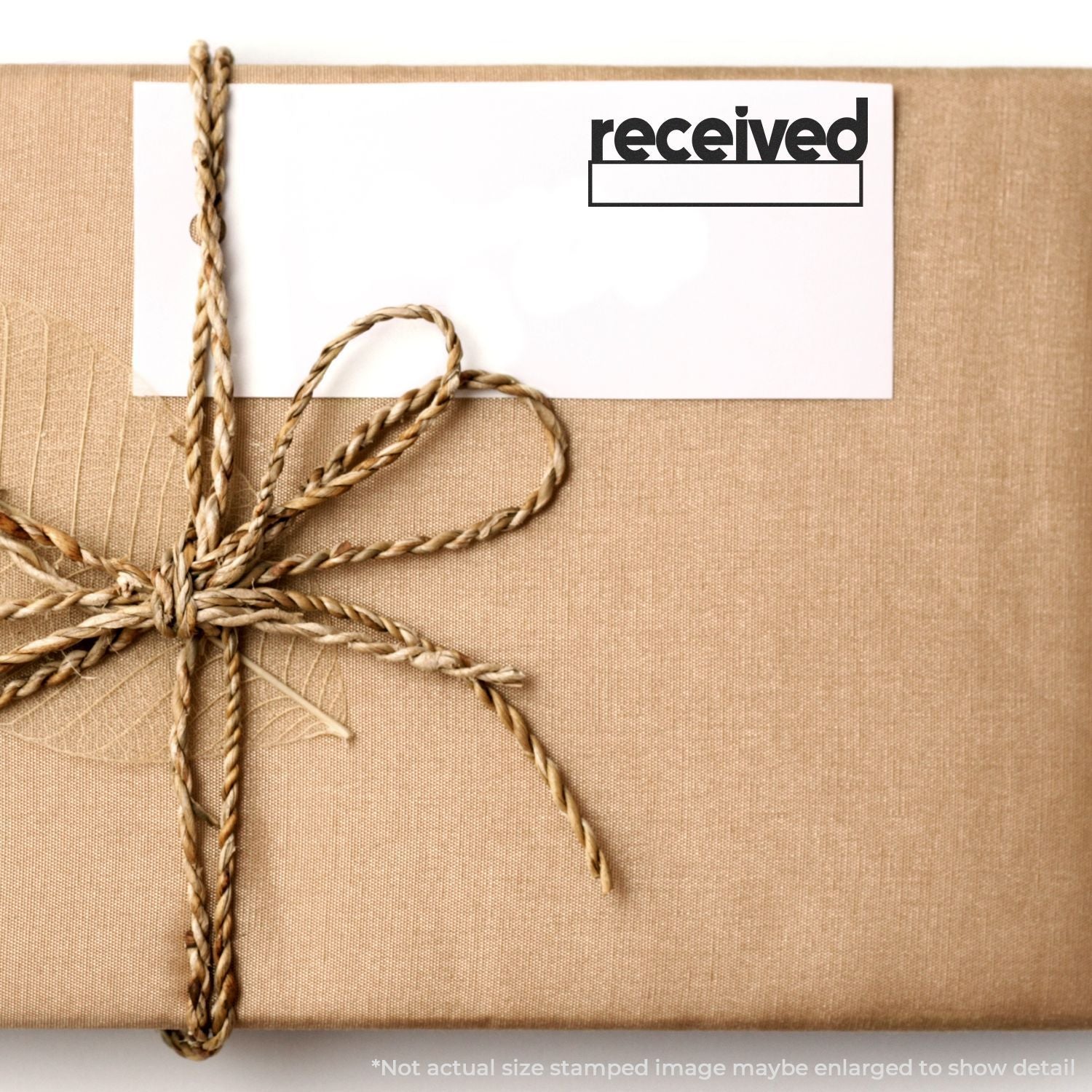 Kraft paper wrapped gift package tied with twine and received label stamp.