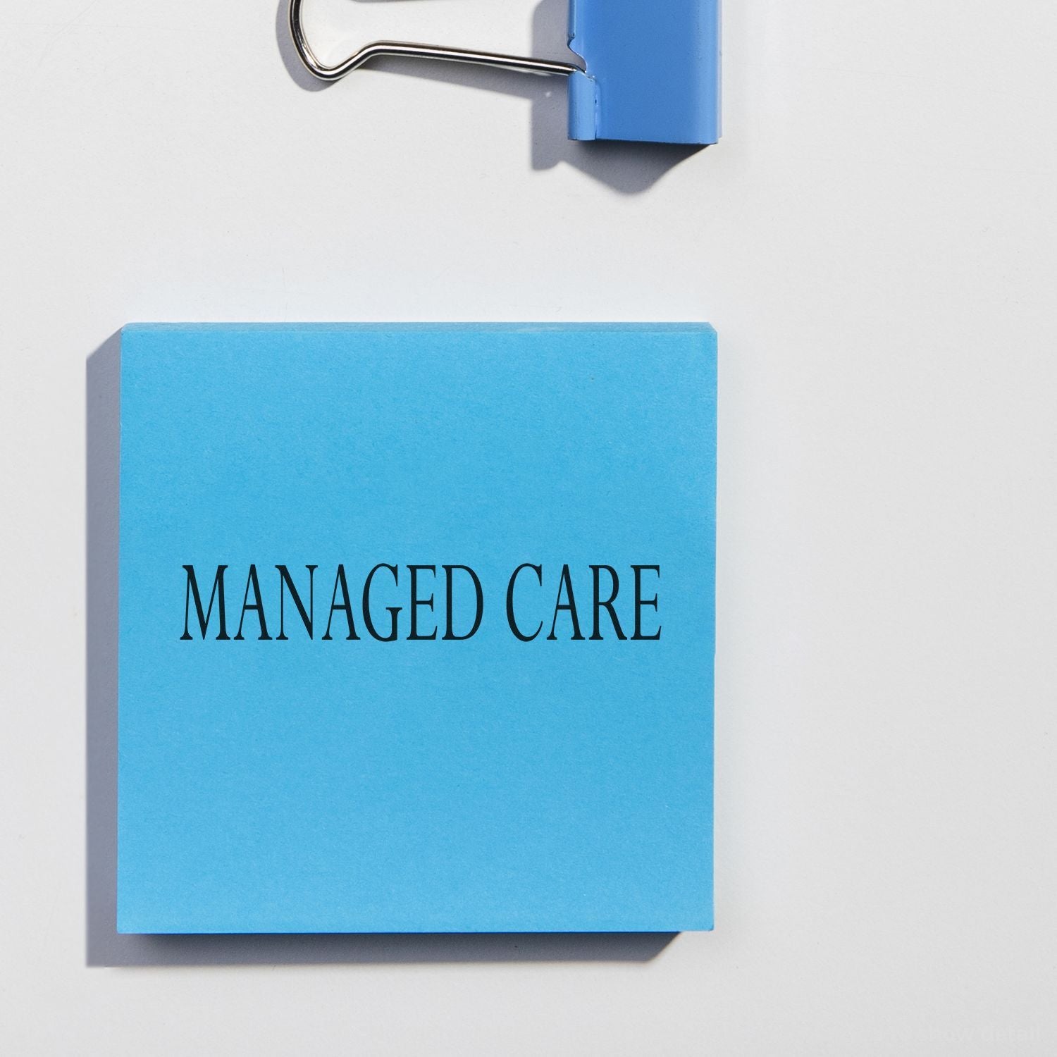 Blue note labeled Managed Care clipped to a white board, healthcare insurance concept.