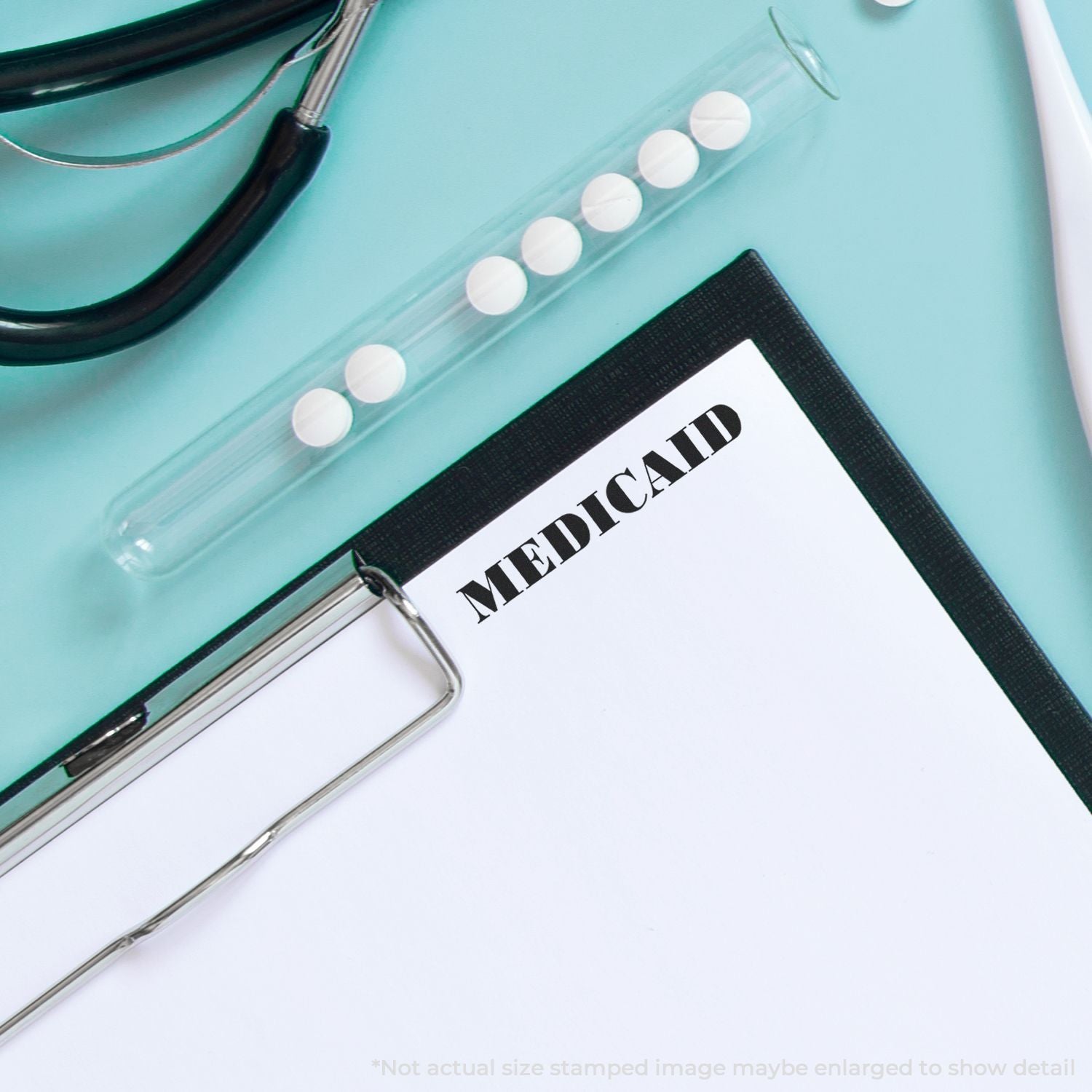 Stethoscope, medication pills, and clipboard with Medicaid form on medical desk.