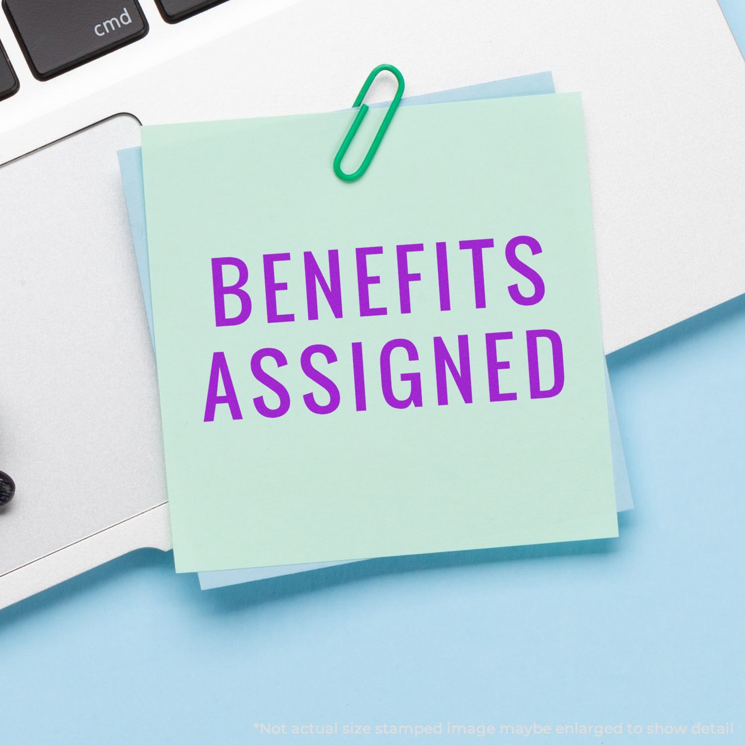 Benefits assigned sticky note on a desk with paperclip, highlighting employee benefits administration and HR documentation