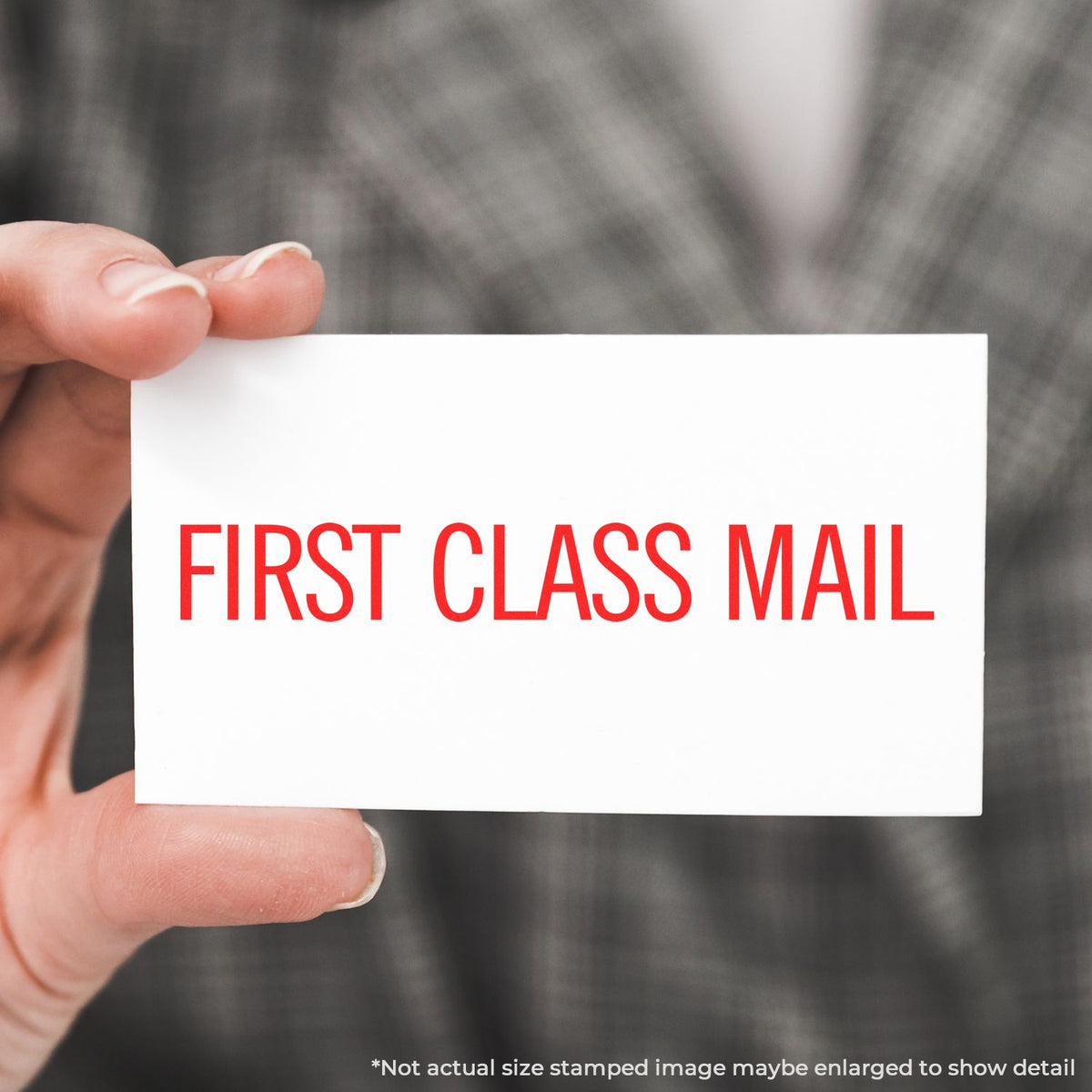 Hand holding a note card that reads FIRST CLASS MAIL, illustrating fast, premium postal service shipping