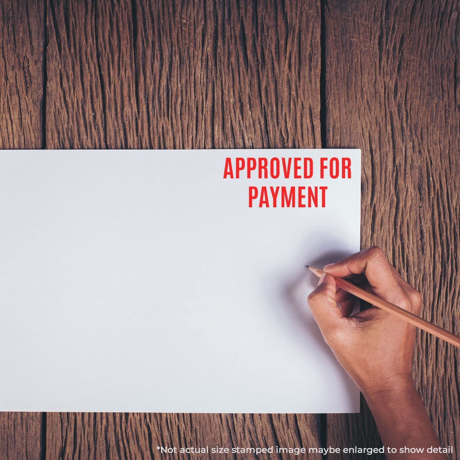 Hand holding pencil over a document stamped Approved for Payment, indicating payment approval for business invoices.