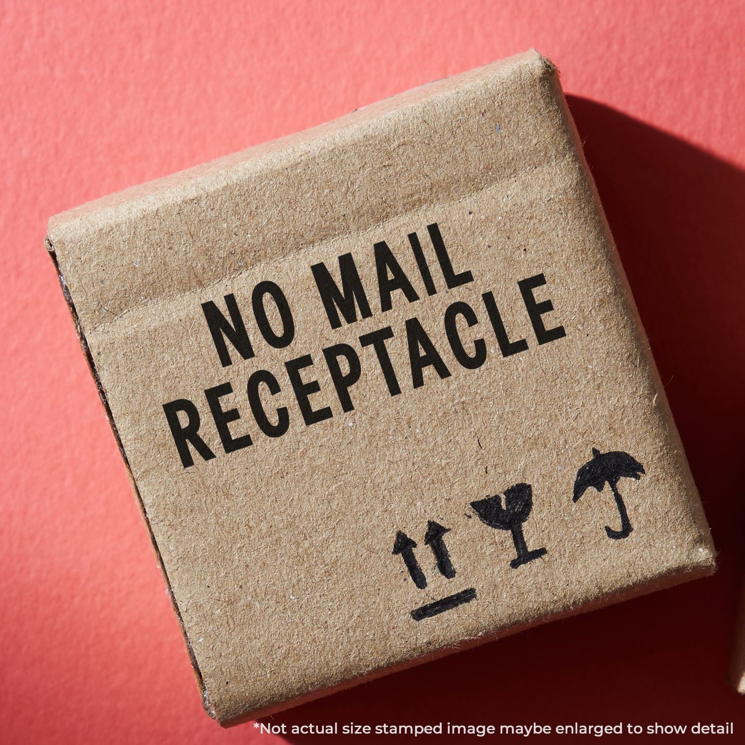 Cardboard box labeled No Mail Receptacle with fragile shipping symbols on red background