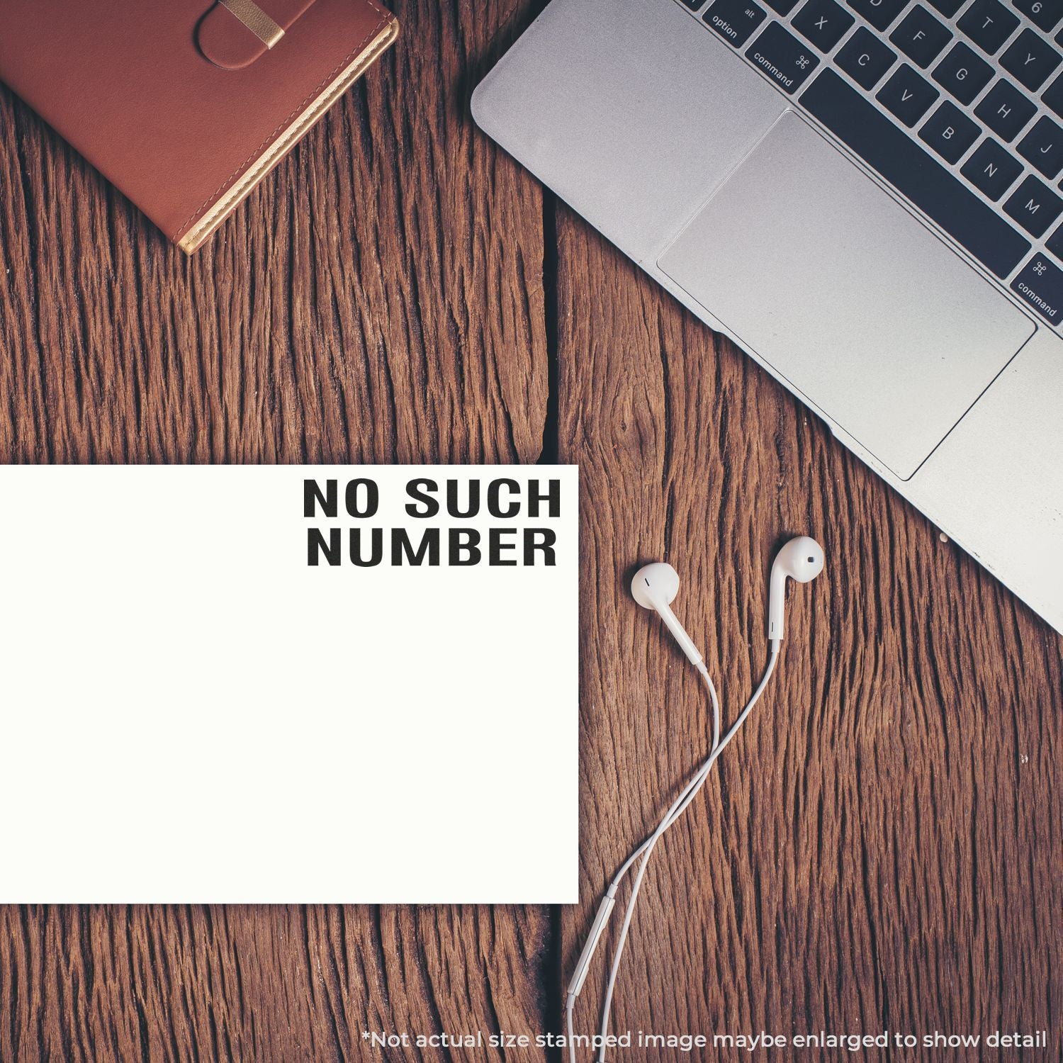 No Such Number stamped on blank paper beside a laptop, earbuds, and wallet on a wooden desk.