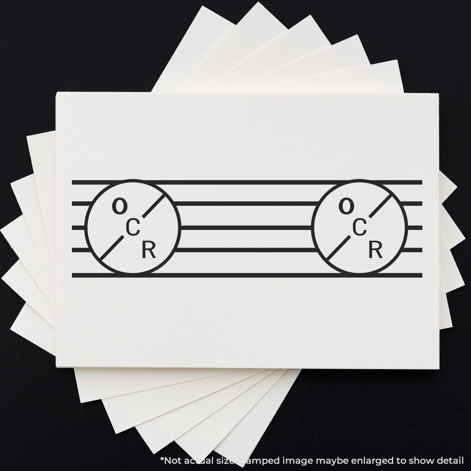 Stack of white cardstock samples with black OCR logo design on a dark background.