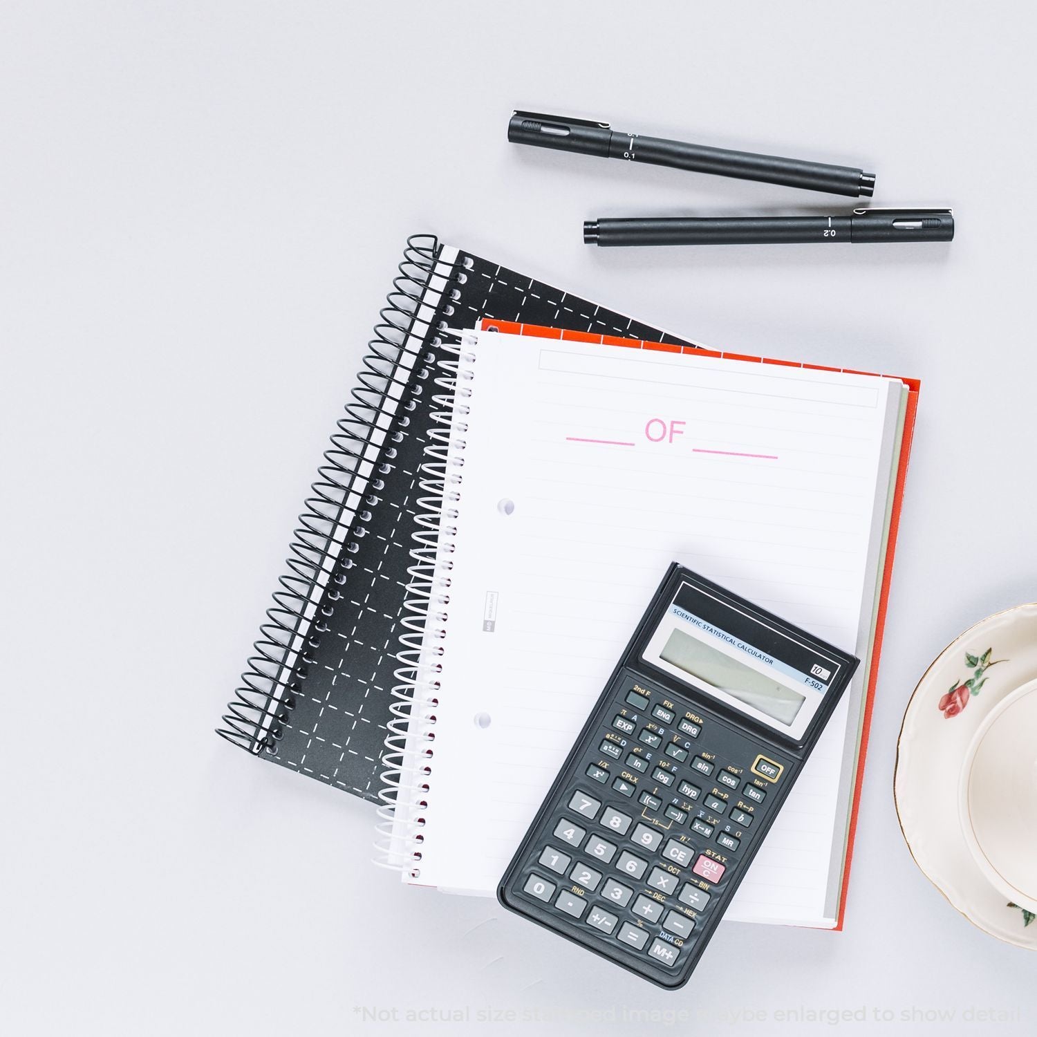 Math and finance study flat lay: scientific calculator with notebook and pens for education, planning, and calculations.