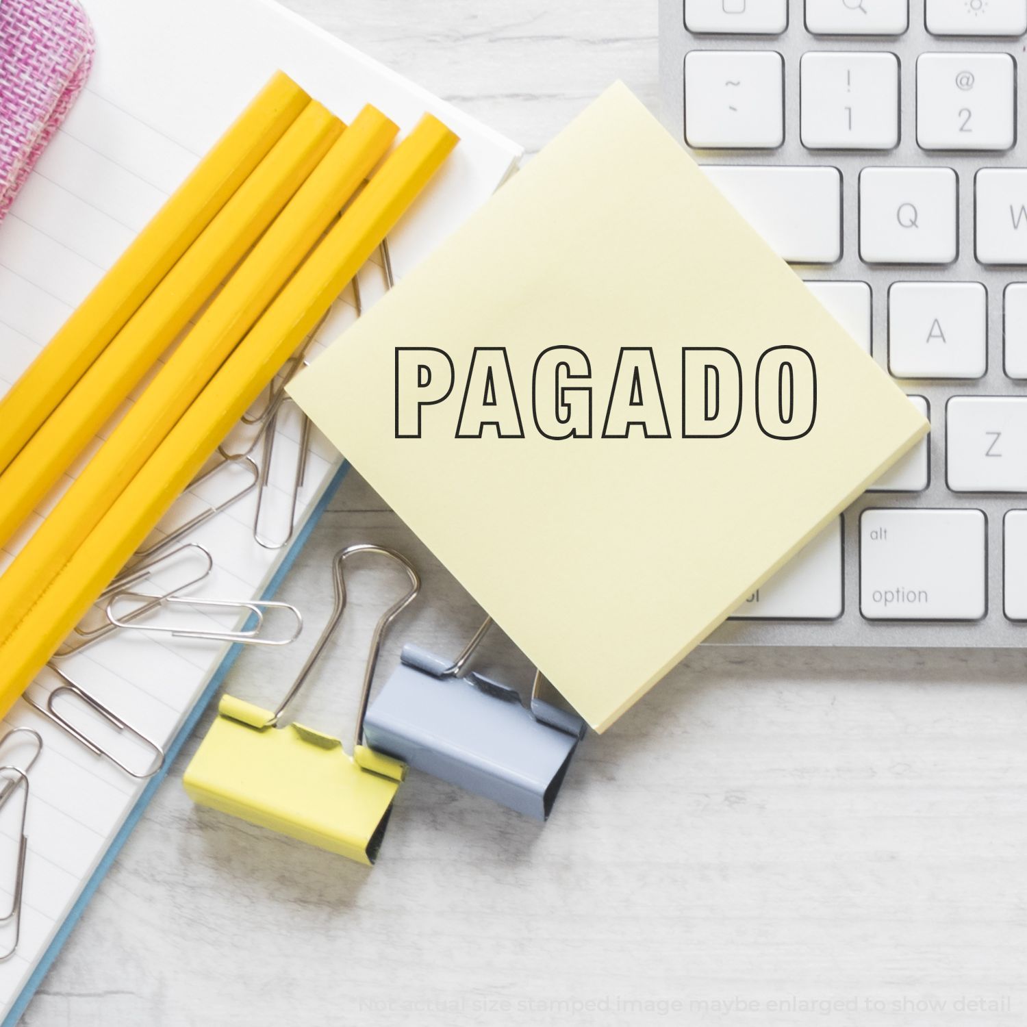 PAGADO status on sticky notes with stationery and keyboard, indicating paid invoice or payment confirmation for budgeting.