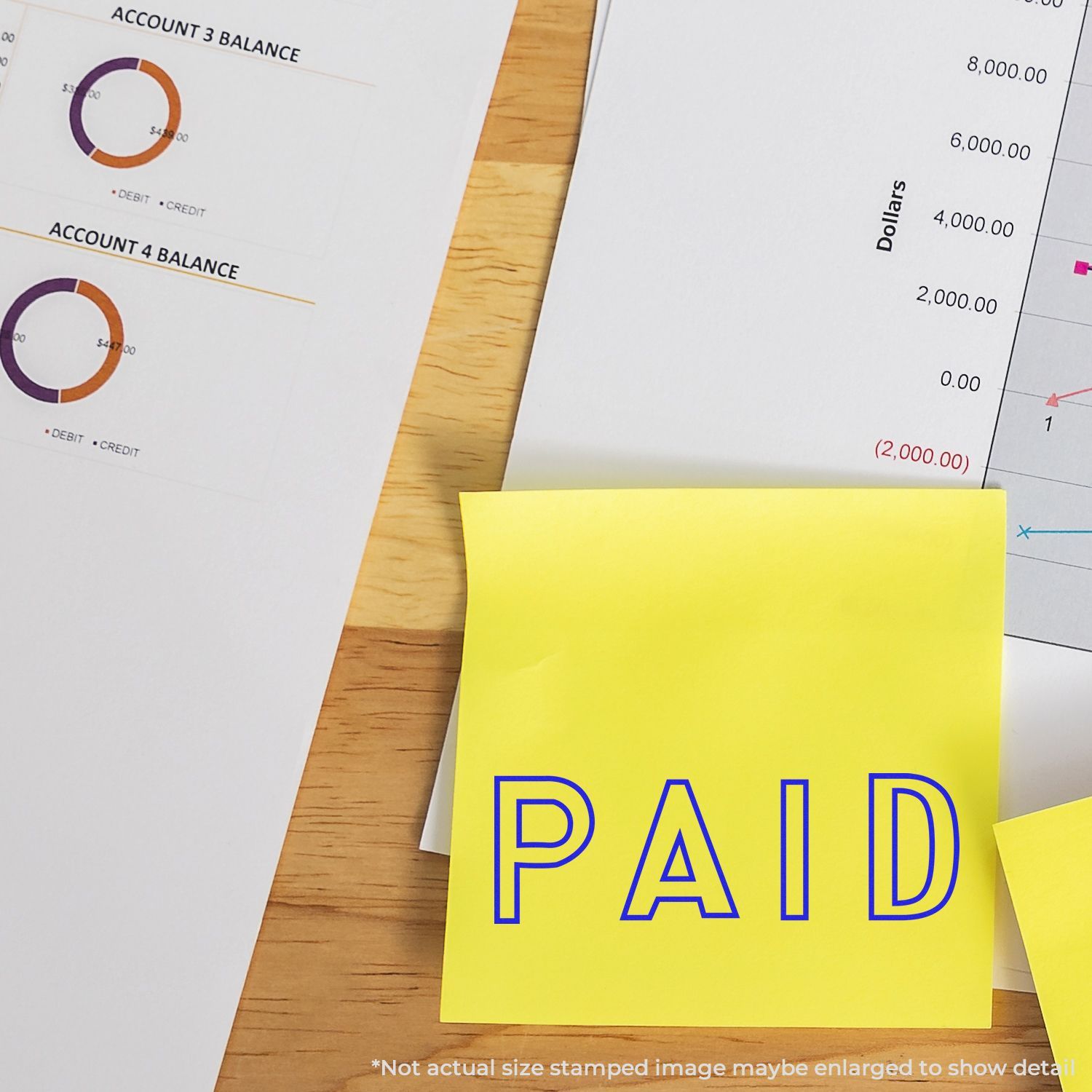 Yellow PAID sticky note on financial reports with charts and account balance graphs on a wooden desk, concept of invoice payment and accounting.
