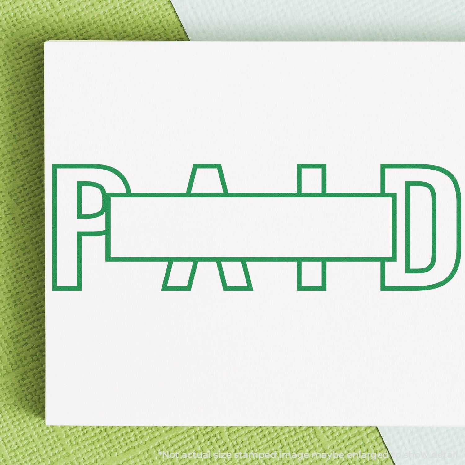 Green PAID stamp on white paper, close-up of payment confirmation on invoice or document.