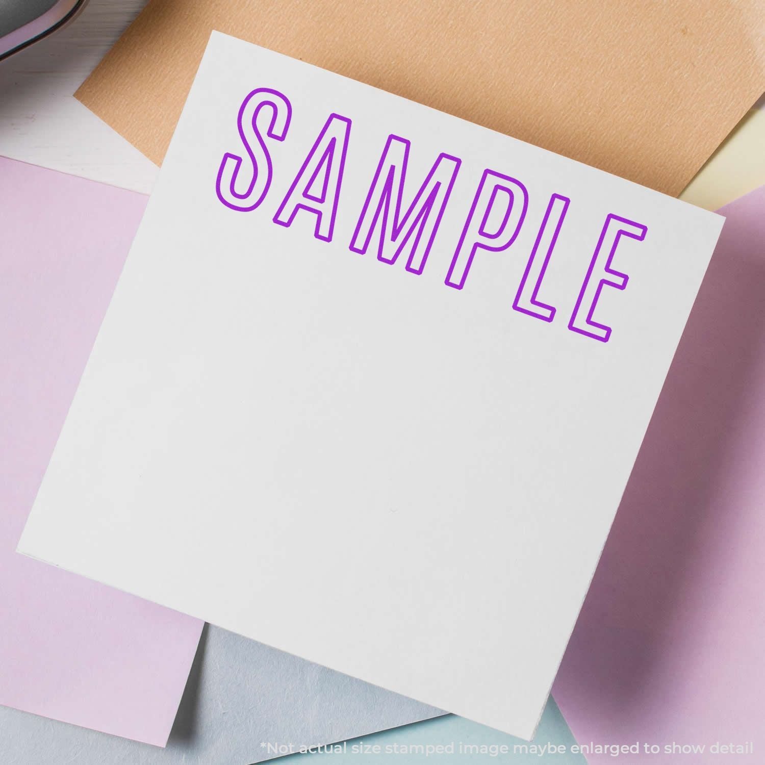 Stationery sample card with bold purple SAMPLE text on white paper, showing design or branding typography layout