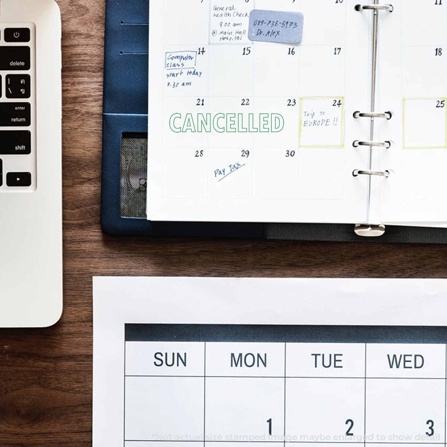 Top view of desk with laptop, paper calendar planner marked cancelled, and weekly schedule pages for office organization and time management.