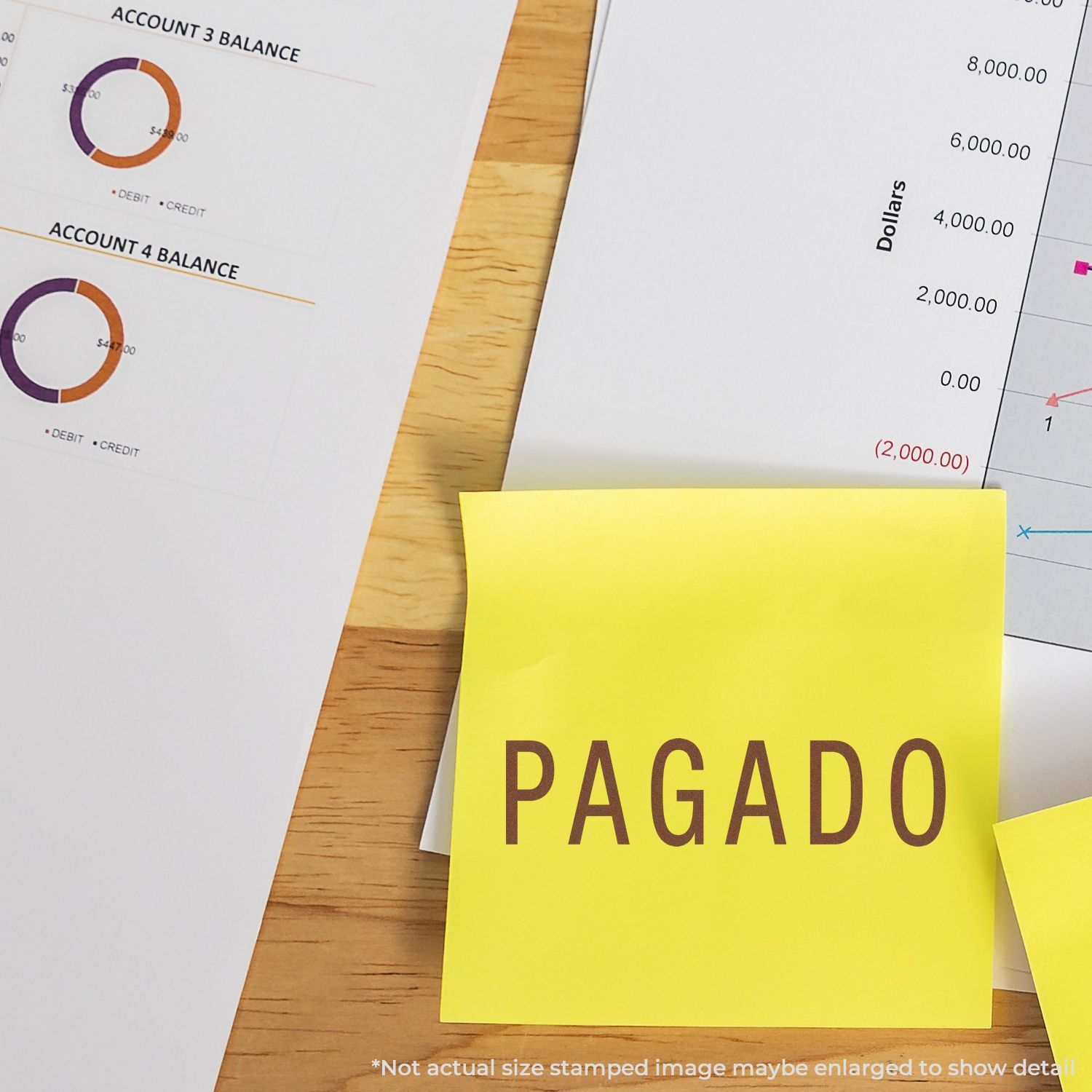 Yellow PAGADO sticky note on accounting reports and financial charts on a wooden desk, indicating a paid invoice or bill.