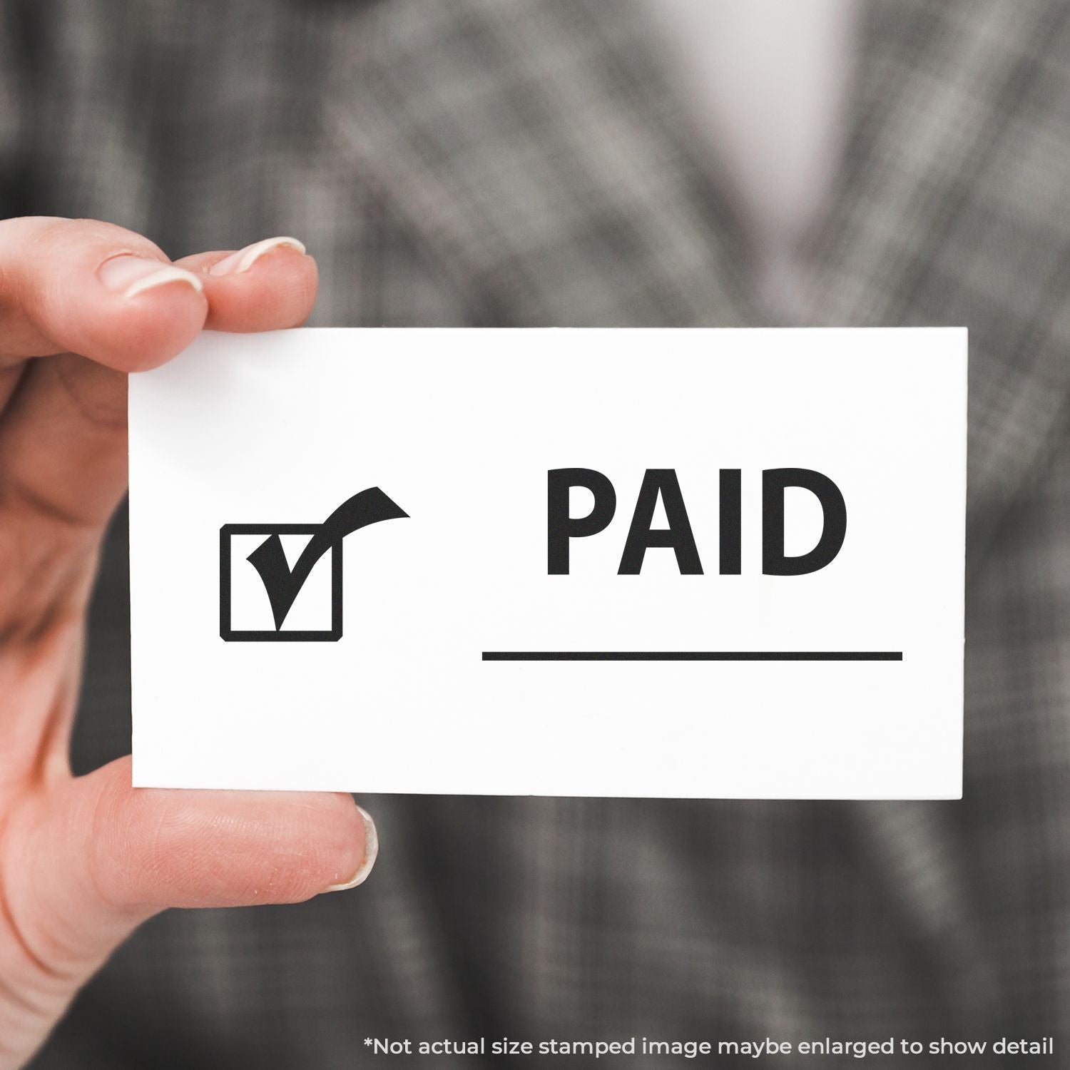 Hand holding a stamped PAID invoice receipt, confirming payment status for bookkeeping and accounting documentation.