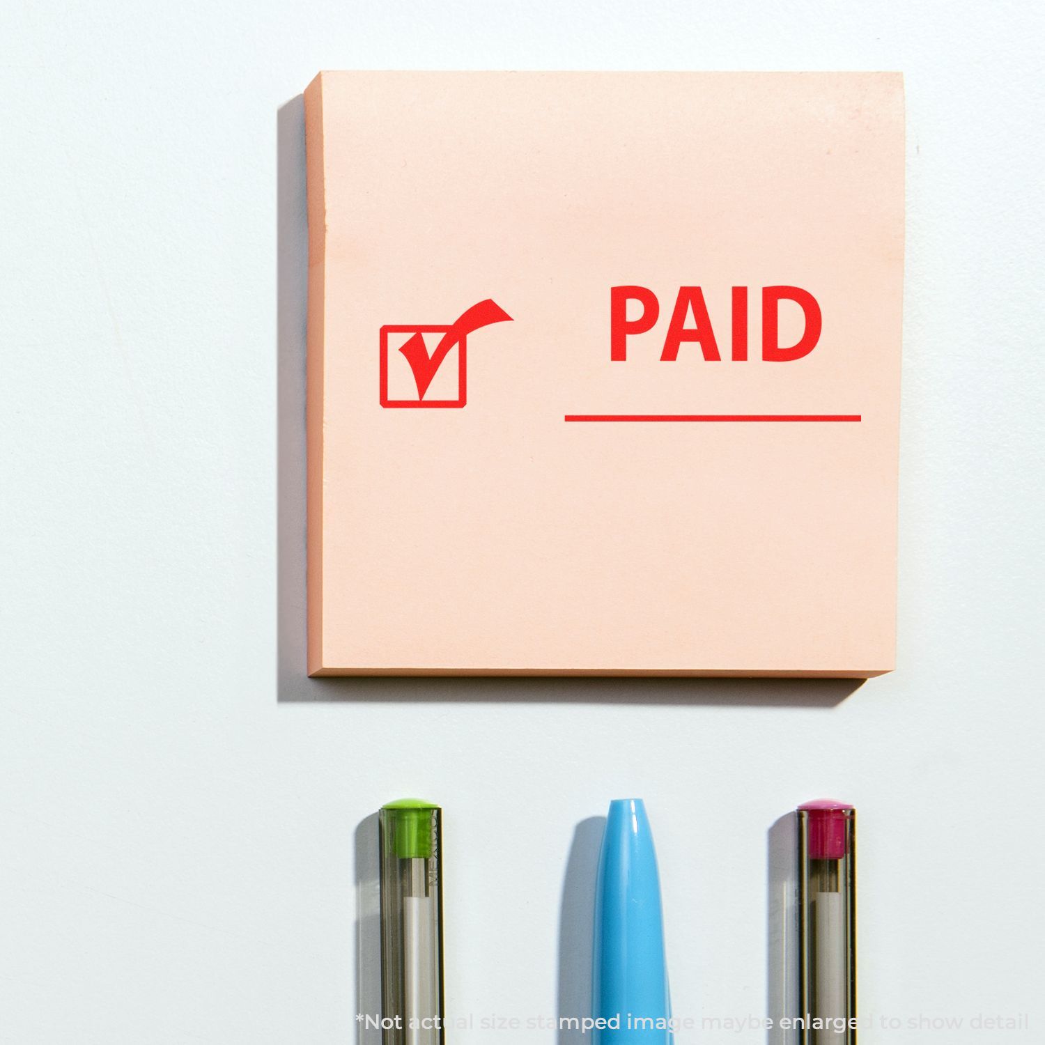 Beige paid stamp block with red checkmark icon and pens on a white background.