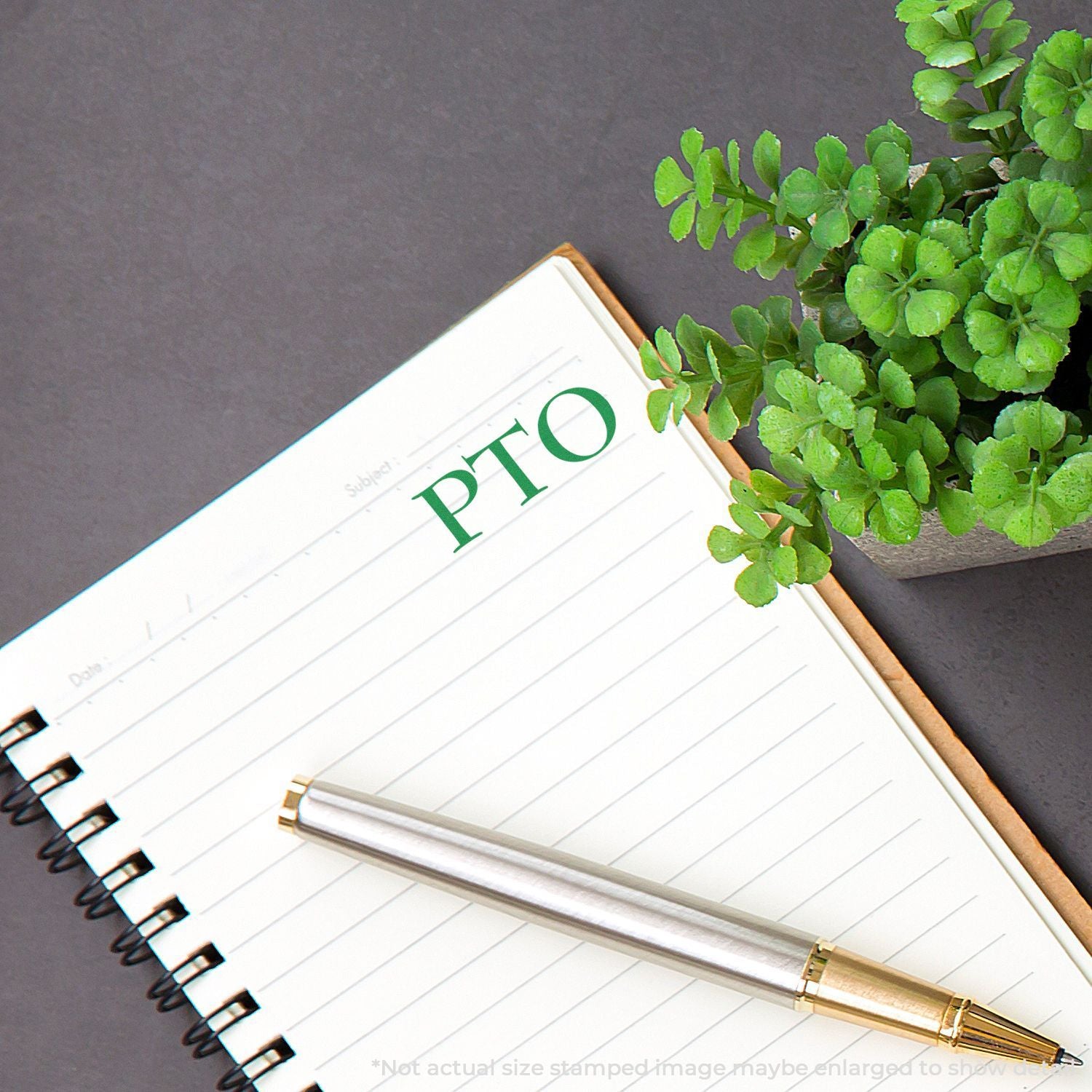 Notebook with green PTO text, pen and fresh plant leaves on dark background for sustainability planning and ideas