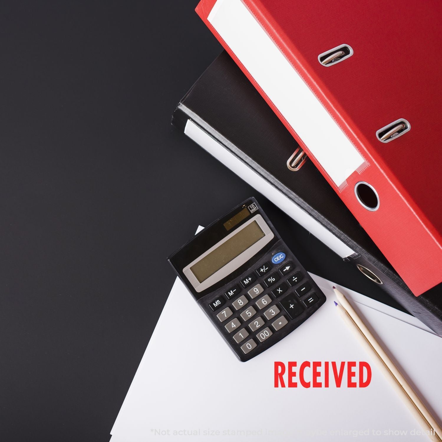 Office paperwork with calculator, red and black binders, and documents stamped RECEIVED on a dark background.