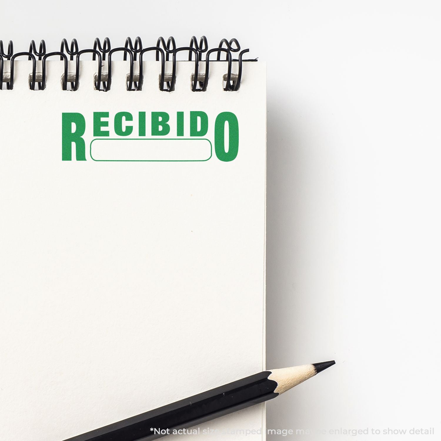 Office paperwork message RECIBIDO on a clipboard with spiral binder clips and pencil, Spanish document receipt note.