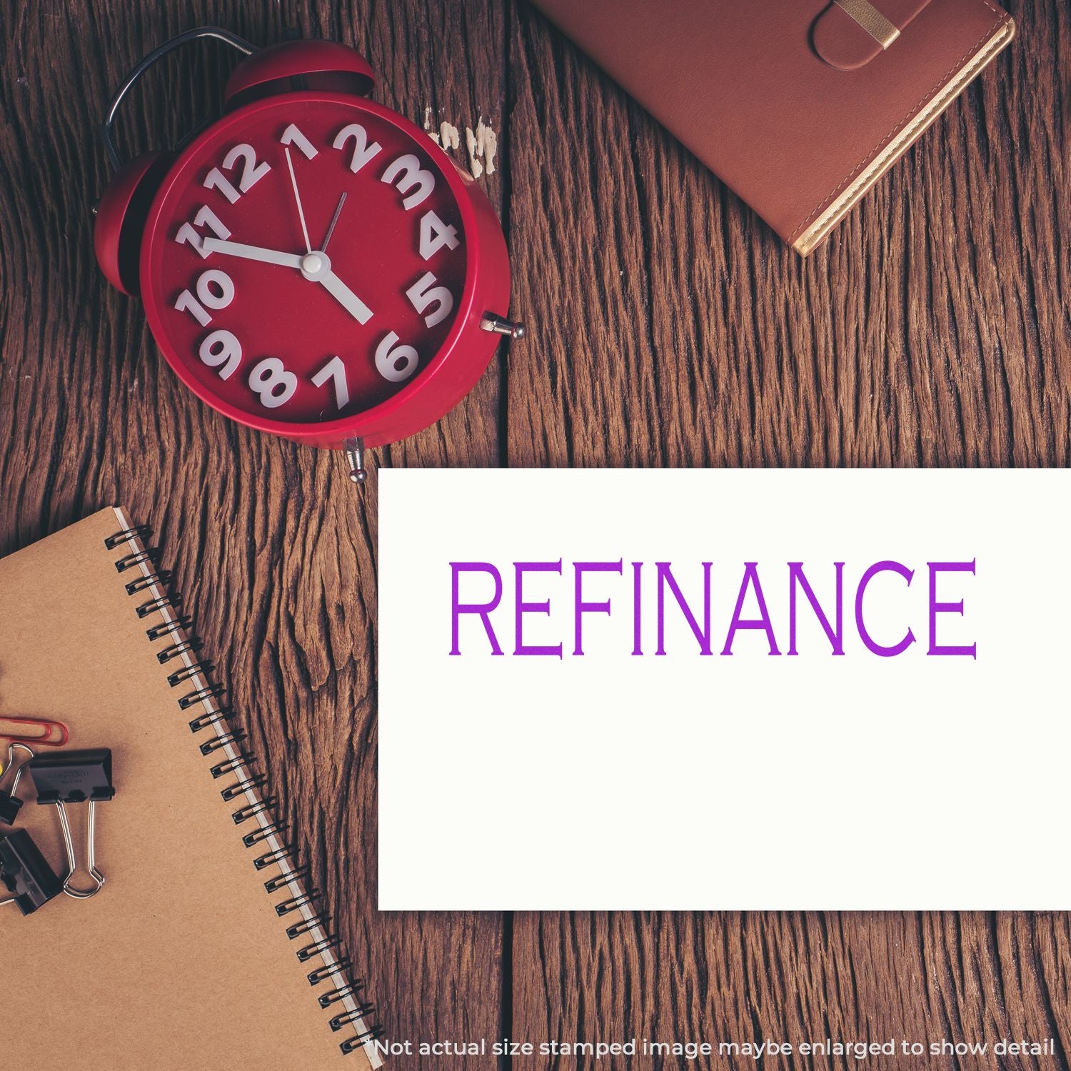 Red alarm clock on wooden desk with notebook and refinance sign, symbolizing mortgage refinancing deadline.