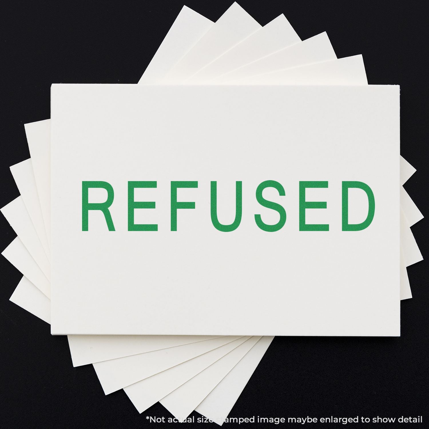 Stack of recycled paper sheets with REFUSED printed in green, eco-friendly office stationery concept