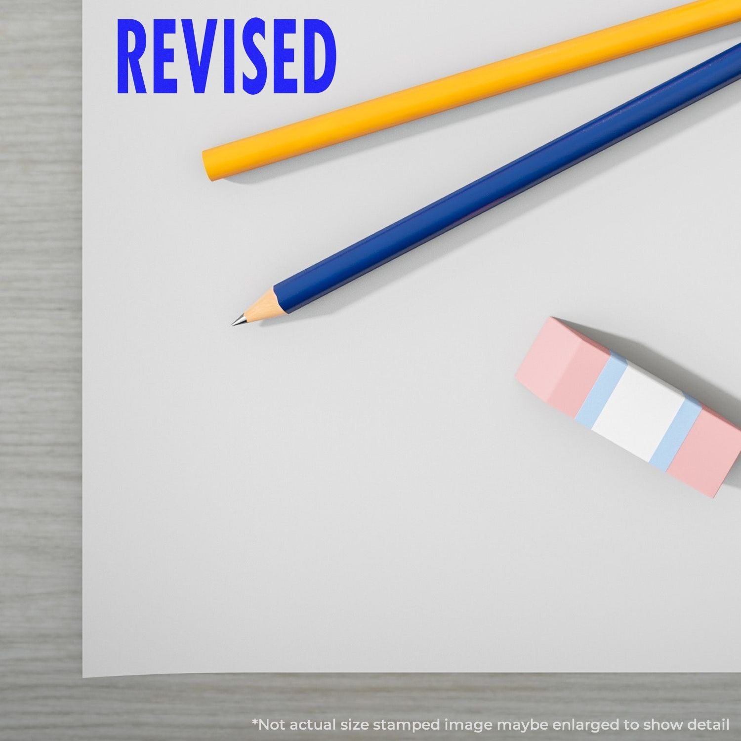 Revised editing concept: blue and yellow pencils beside the word REVISED on a page, promoting proofreading and content improvement.