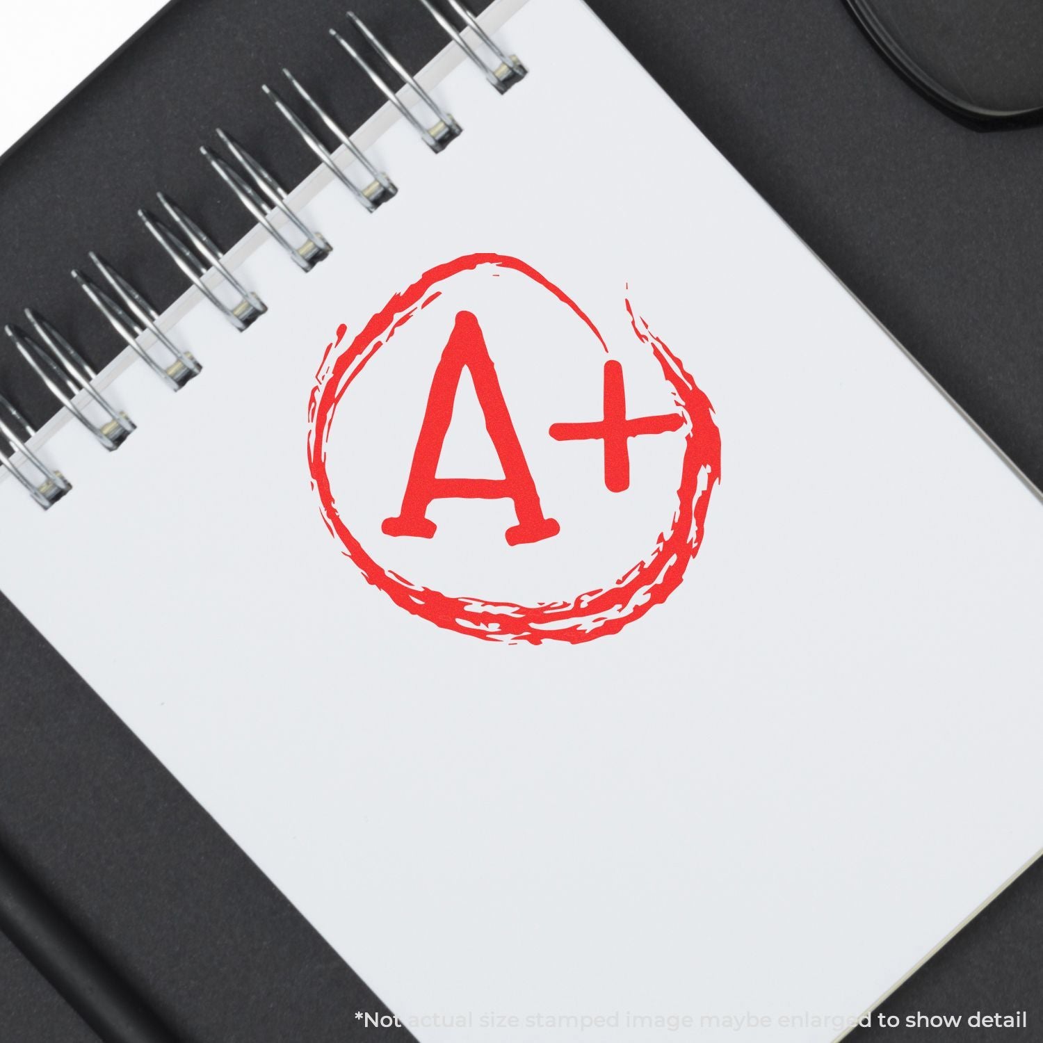A+ grade stamp on a spiral notebook, symbolizing excellent academic performance and success.