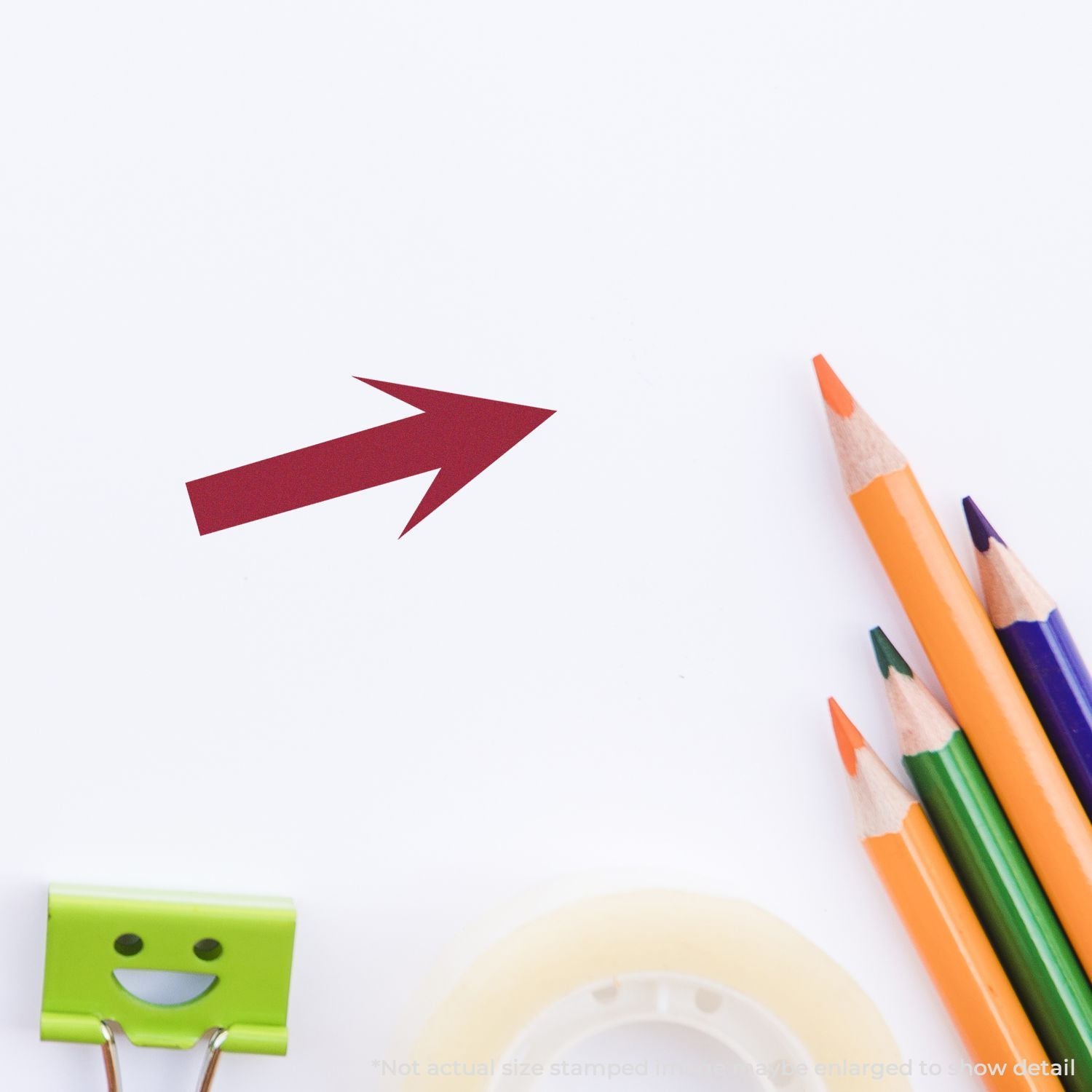Color pencils, red arrow, and blank white paper with stationery supplies on a clean creative workspace.