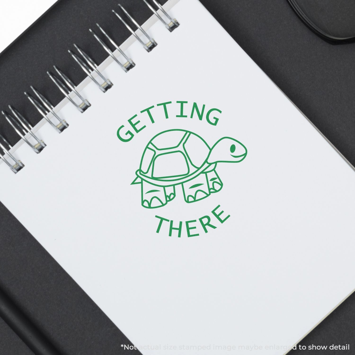 Spiral notebook with green turtle Getting There logo on white cover, eco-friendly motivational design.