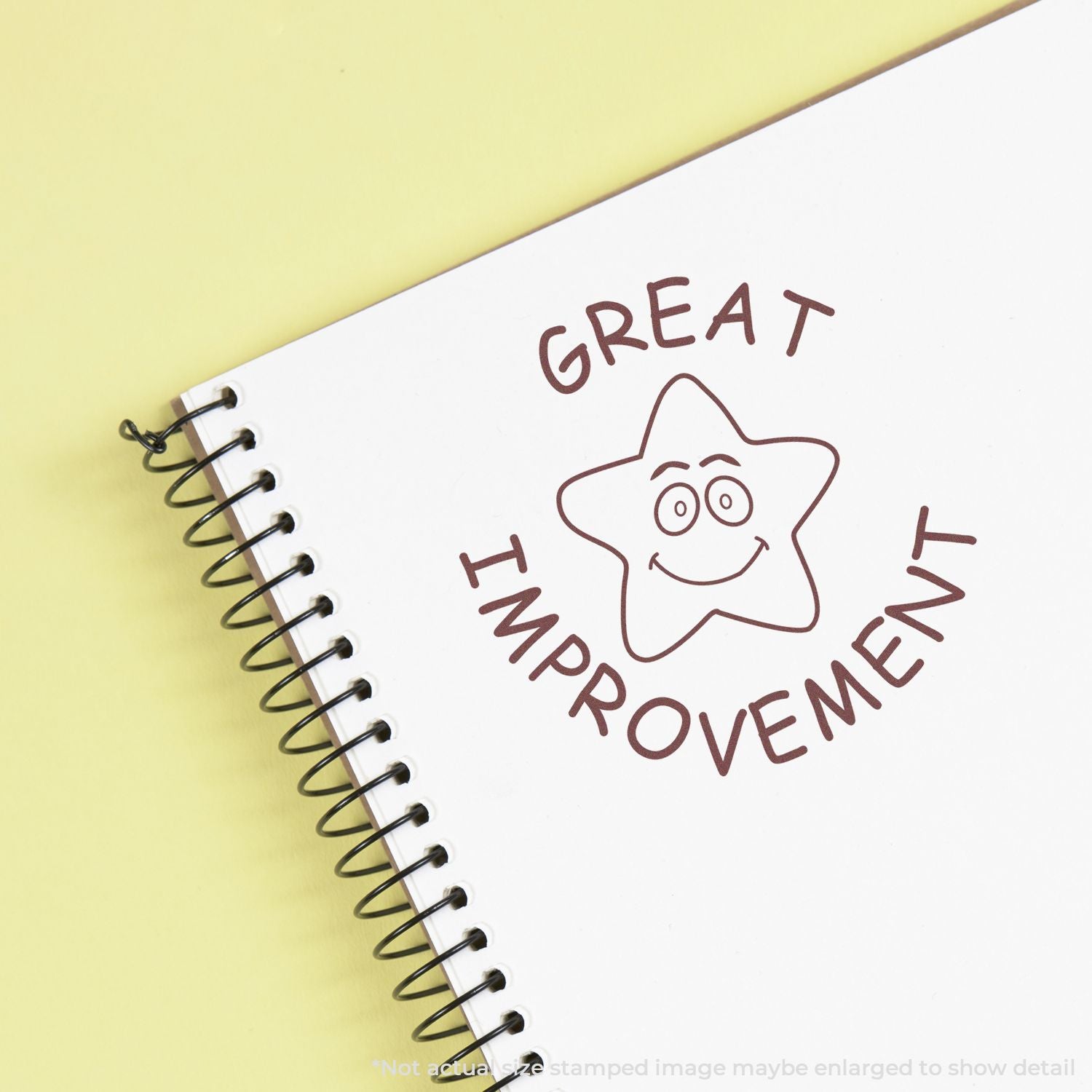 Spiral notebook with Great Improvement star doodle on a yellow background.