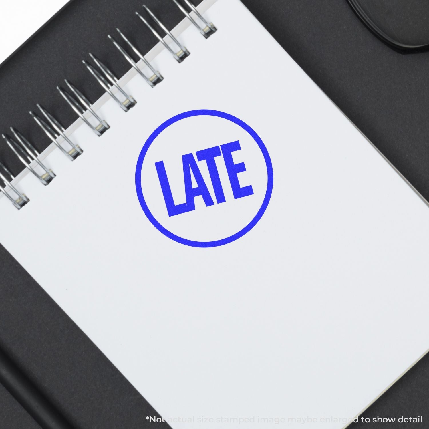 Blue LATE stamp on a spiral notebook, symbolizing deadline delay, missed appointment, or time management concept.