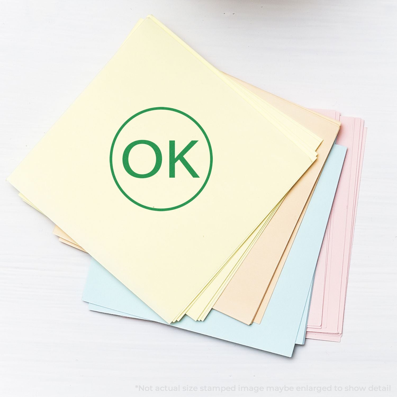 Pastel colored paper stack with green OK stamp on white background.