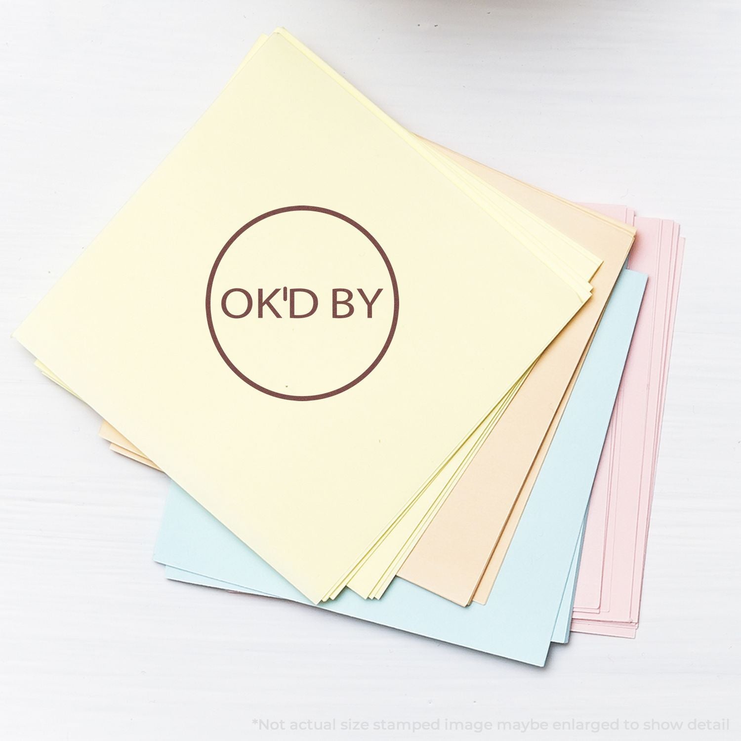 Pastel cardstock paper stack with OK'D BY logo, colorful stationery sheets on a white background