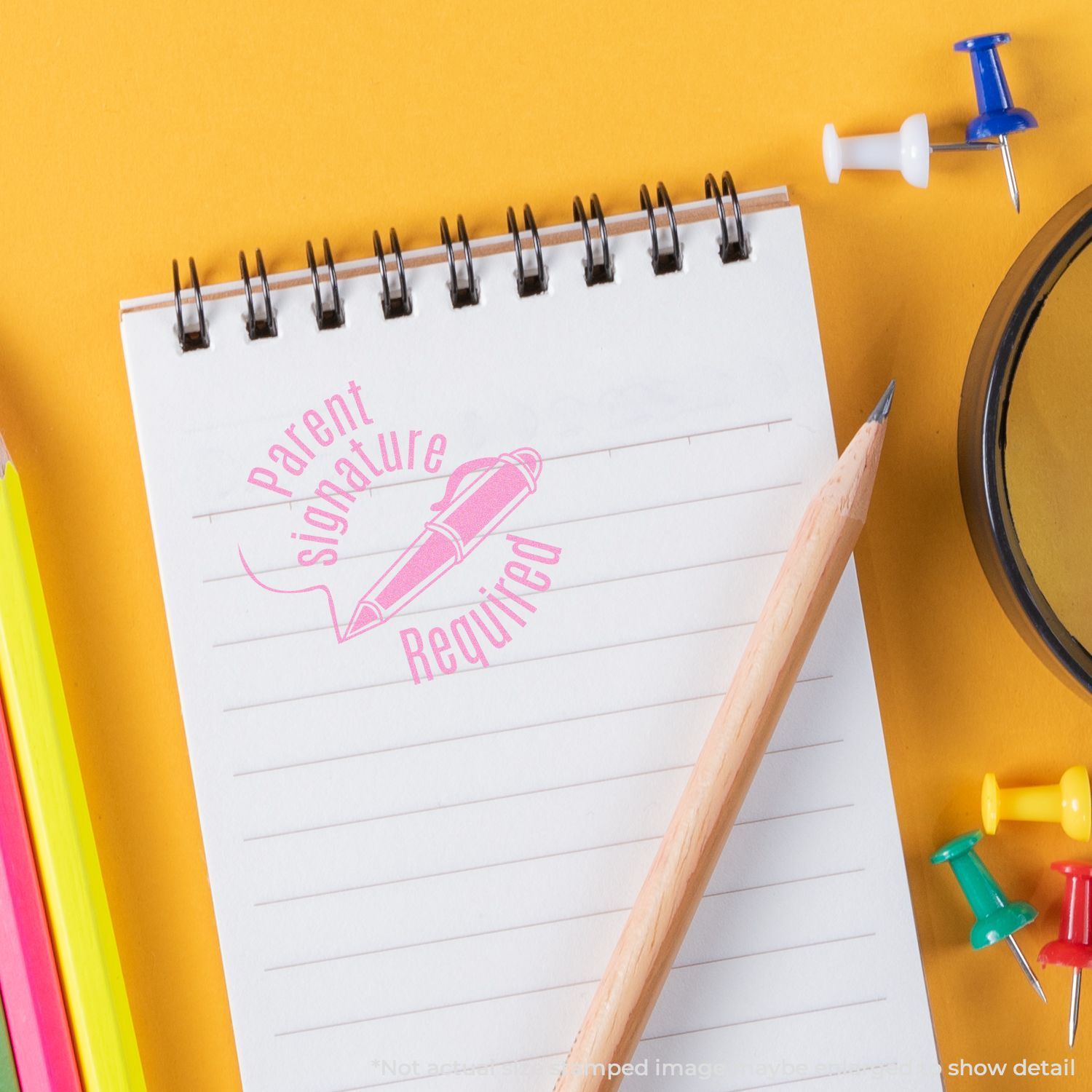 Parent signature required stamp on spiral notepad with pencil and colorful push pins on yellow background