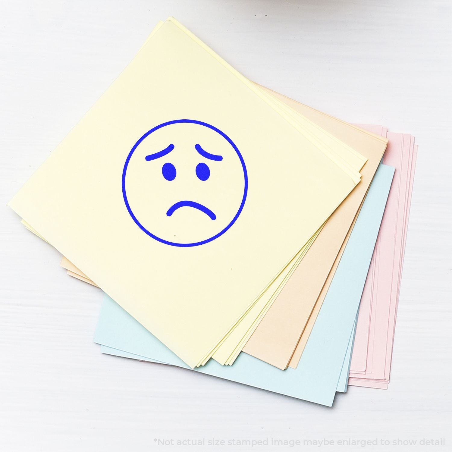Stack of pastel paper sheets with sad face icon, stationery background illustration