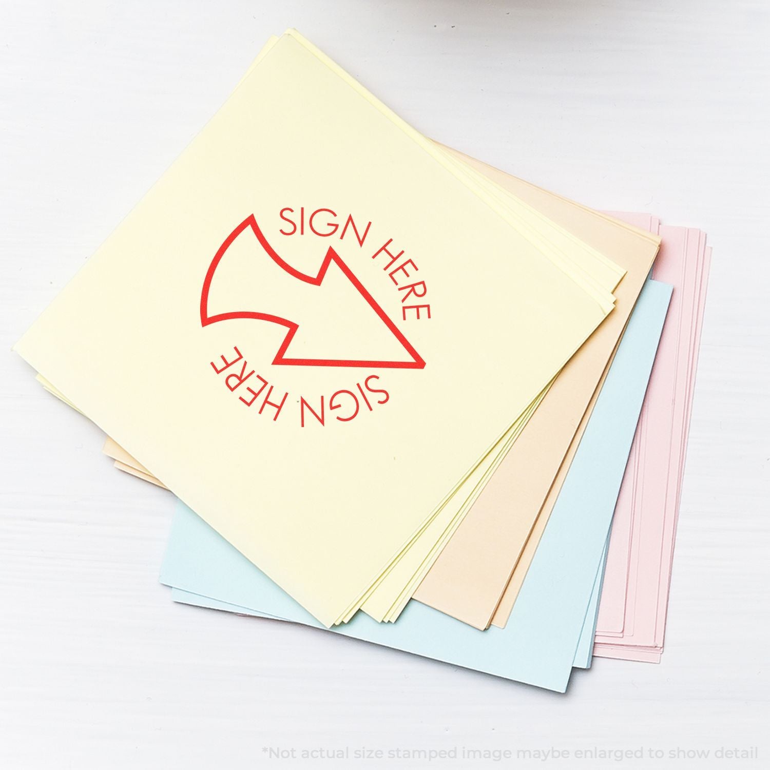 Stack of pastel-colored signature stickers with red sign here arrow for document marking and office organization.