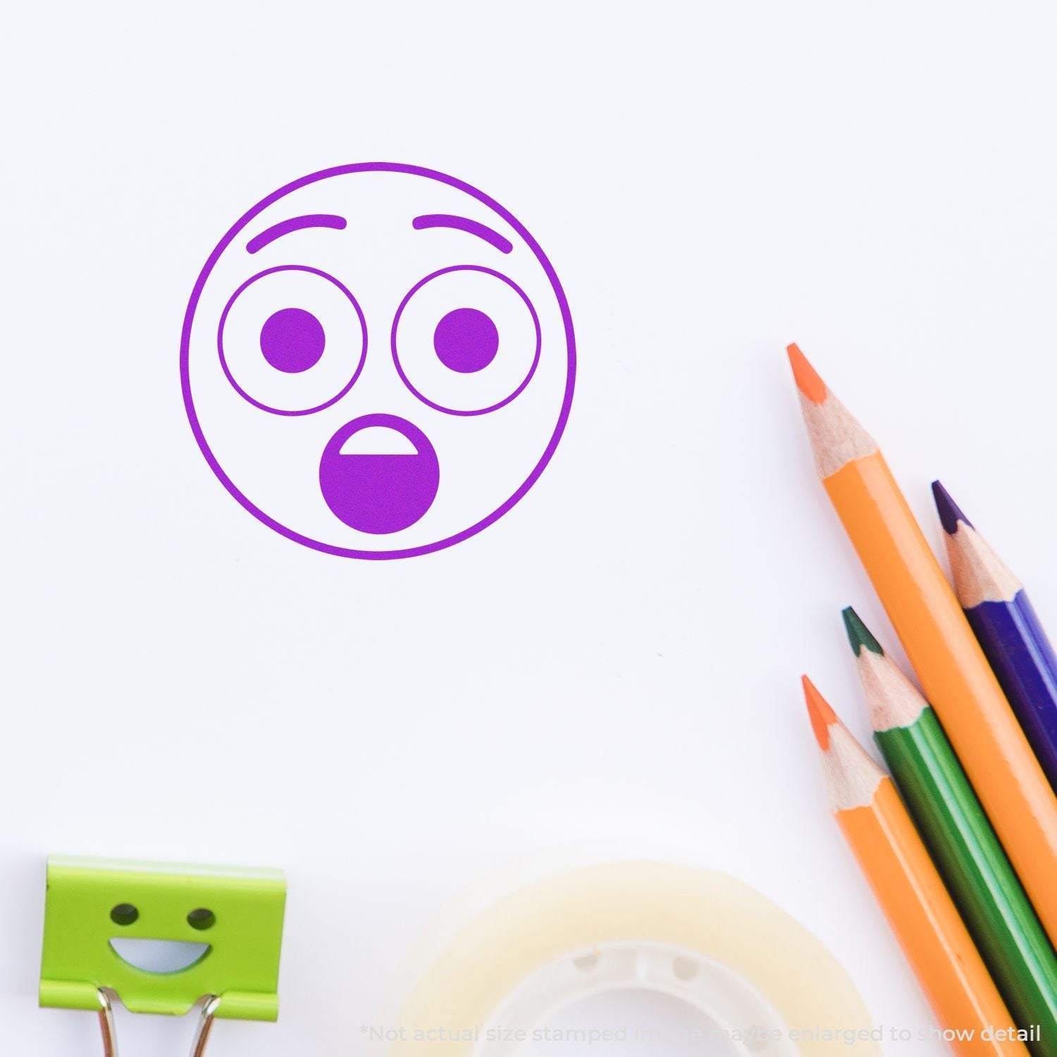 Purple surprised emoji face stamp on white paper with colorful pencils, creative school art concept.