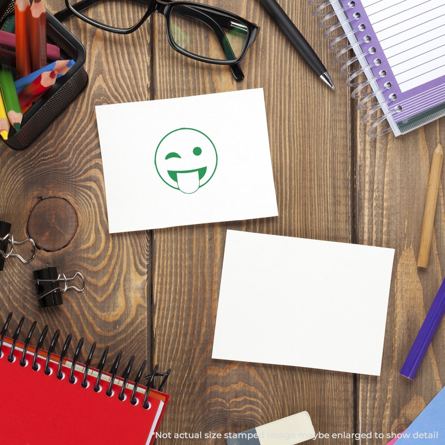 Wooden desk with school supplies and blank sticky notes, featuring a winking smiley face icon on white paper.