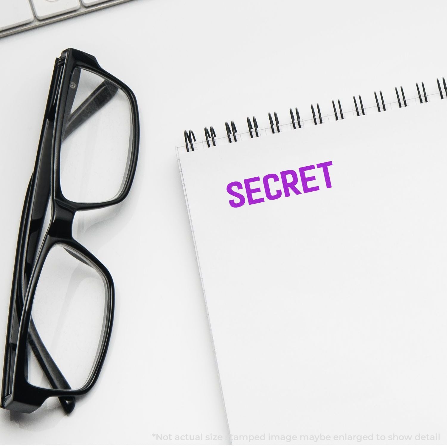 Black eyeglasses beside a notebook labeled SECRET, highlighting confidentiality and security for sensitive information.