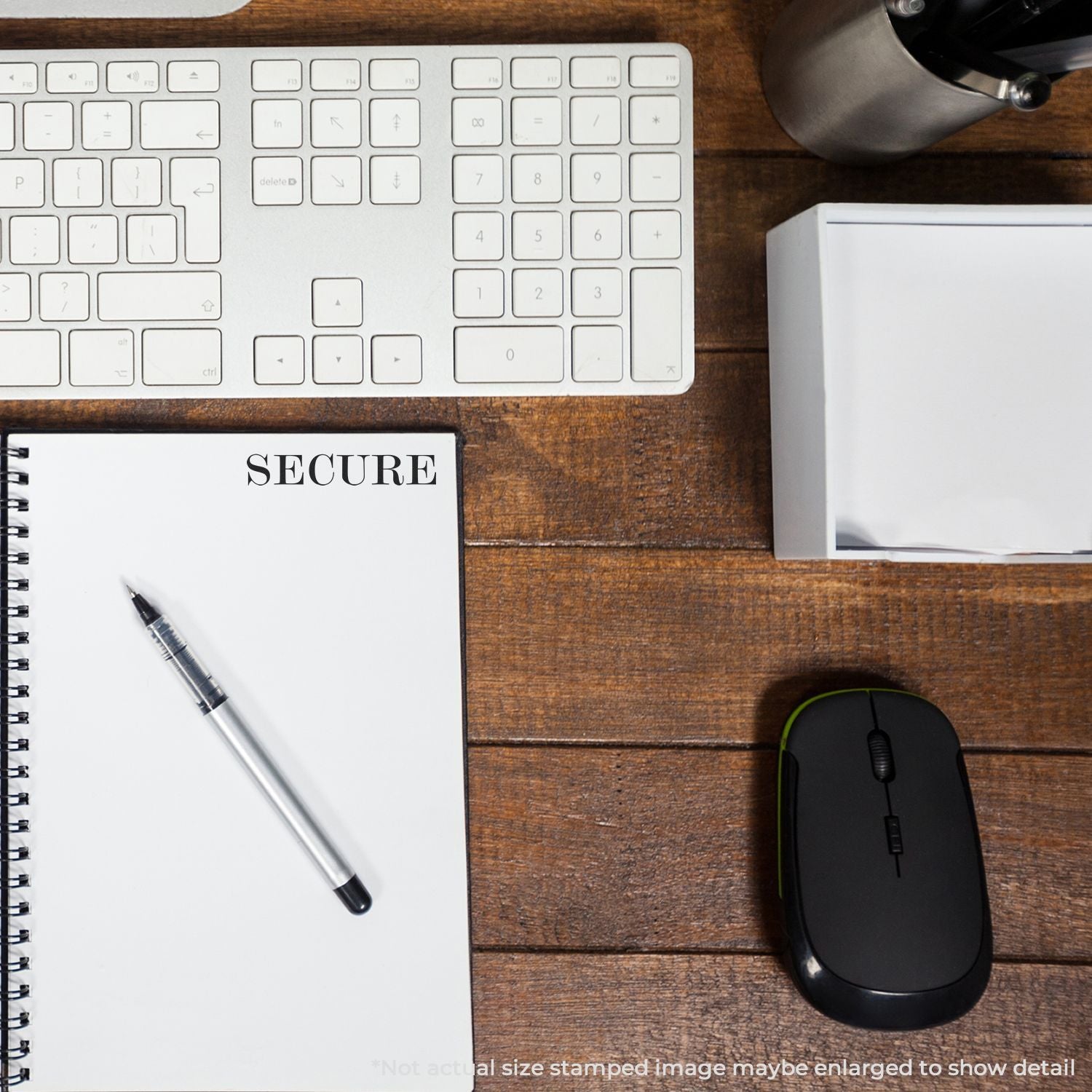 Top view of secure office workspace with keyboard, mouse, notebook, and pen on wooden desk.