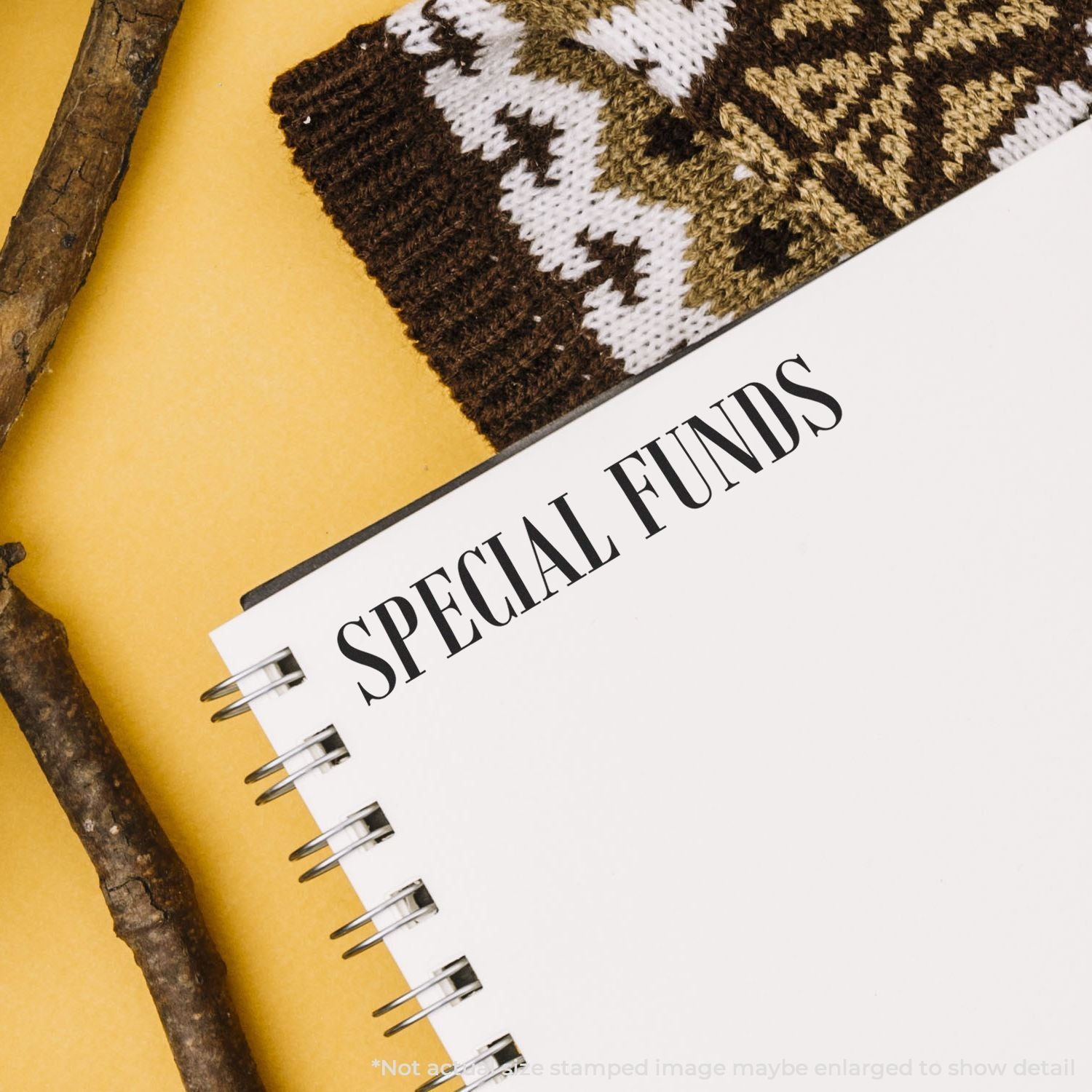 Notebook labeled Special Funds with knitted fabric and rustic sticks on a yellow background, concept of savings and financial planning.