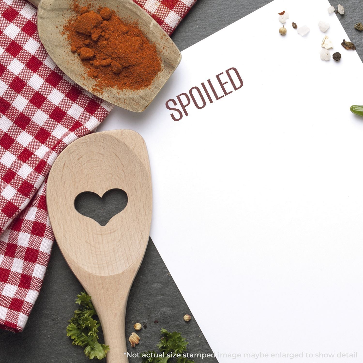 Spiced seasoning concept with paprika powder in wooden spoon beside herbs and spices, recipe cooking inspiration with word SPICED