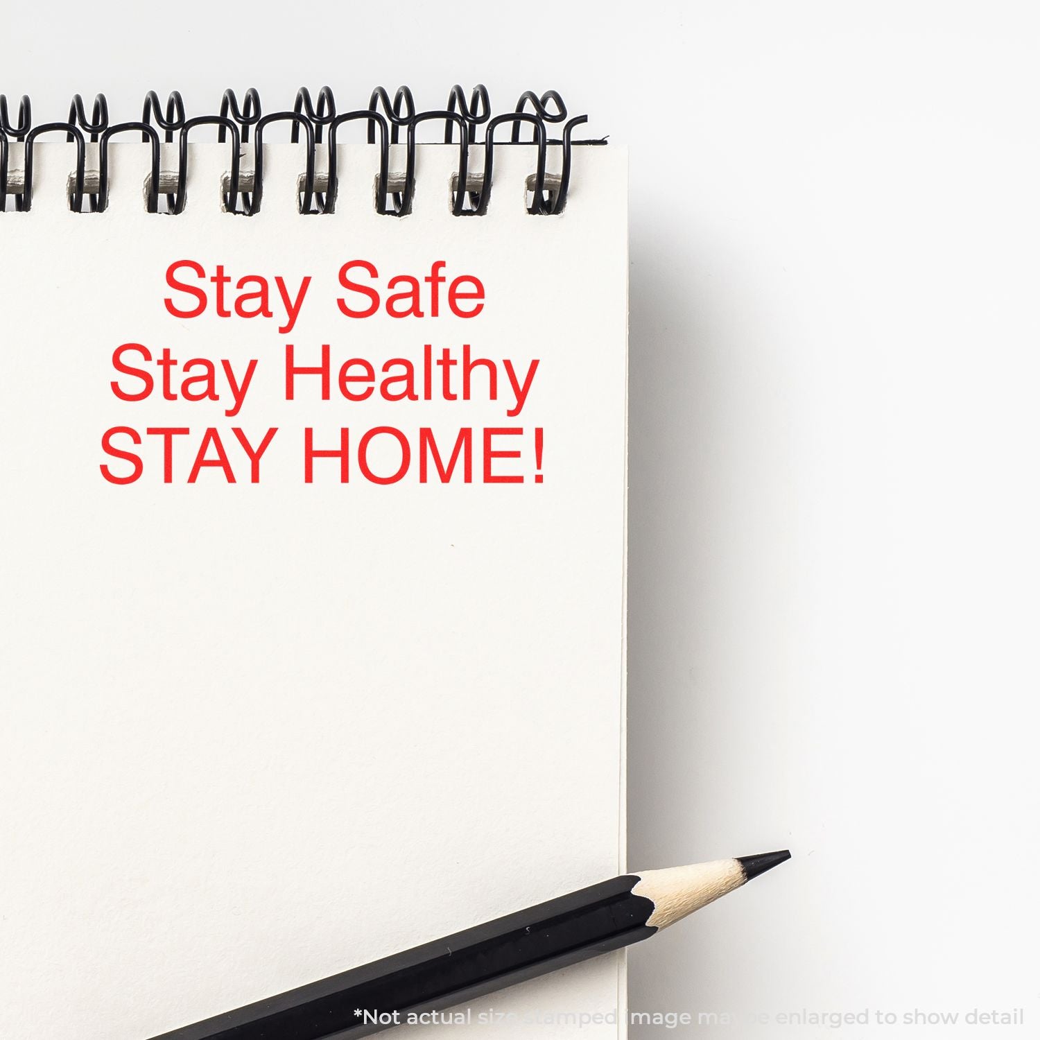 Notepad with red Stay Safe, Stay Healthy, Stay Home message and pencil on a white background