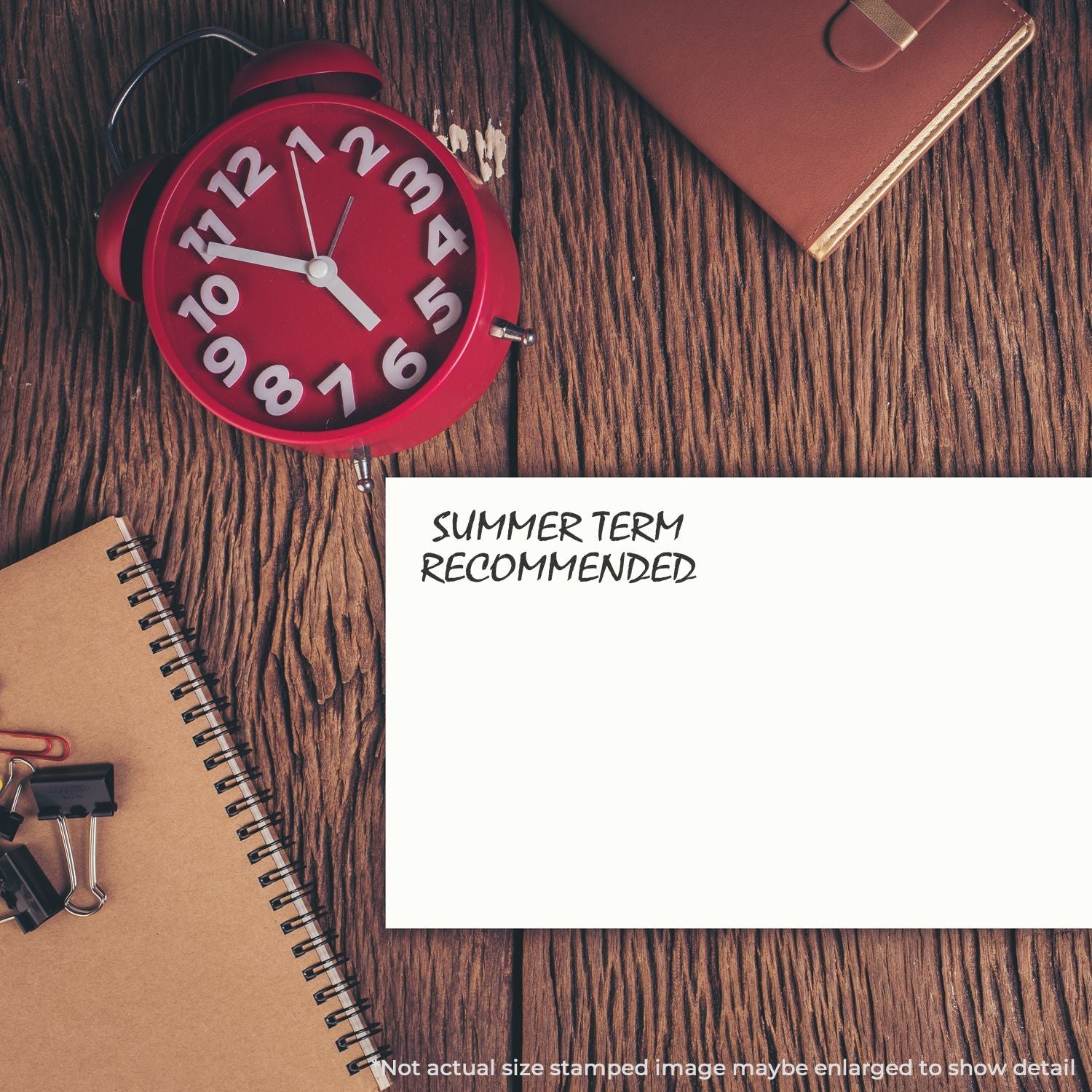Red alarm clock beside notebooks and stationery with text Summer Term Recommended, promoting back-to-school summer planning.