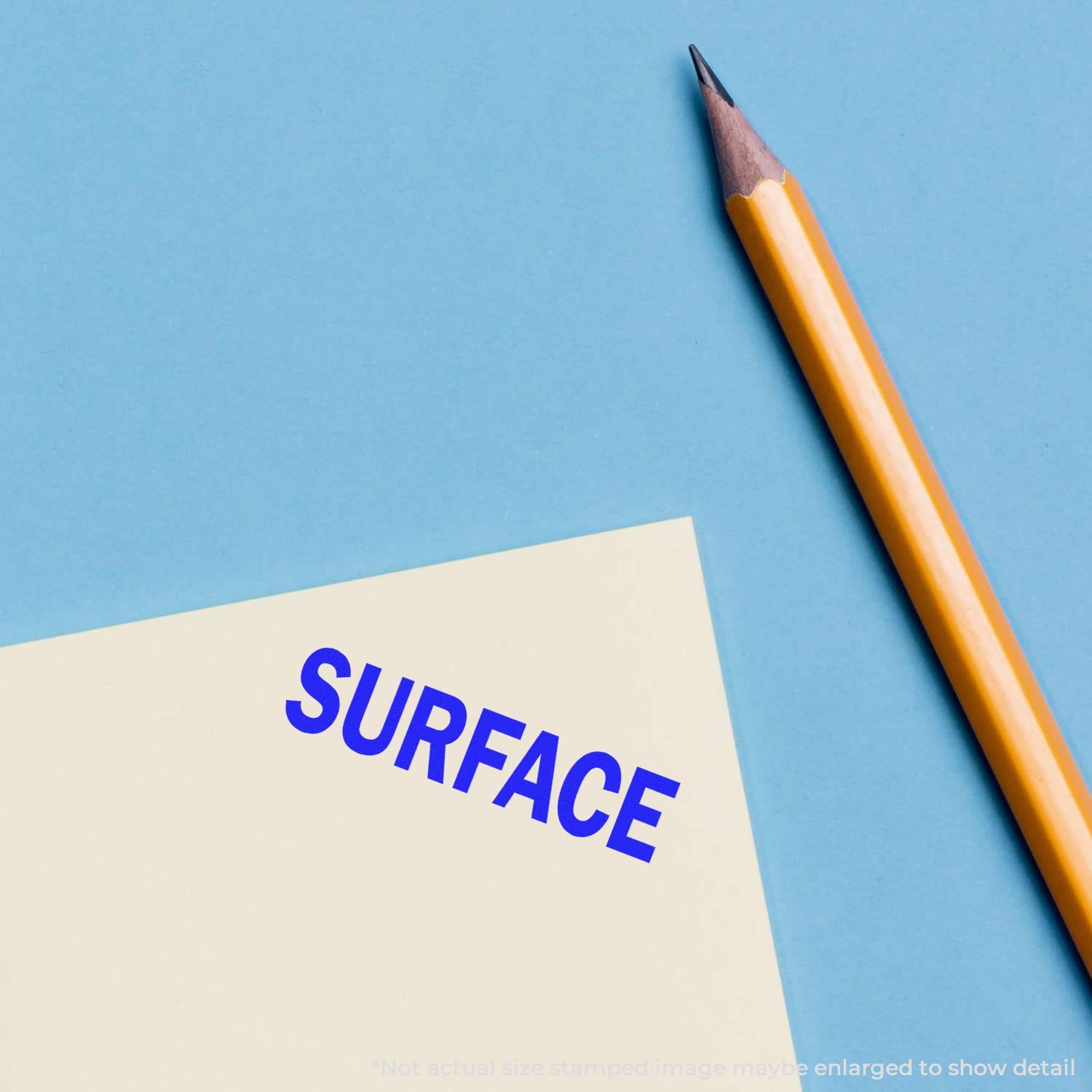 Surface concept photo with pencil and notes card reading SURFACE on blue background for education and design.
