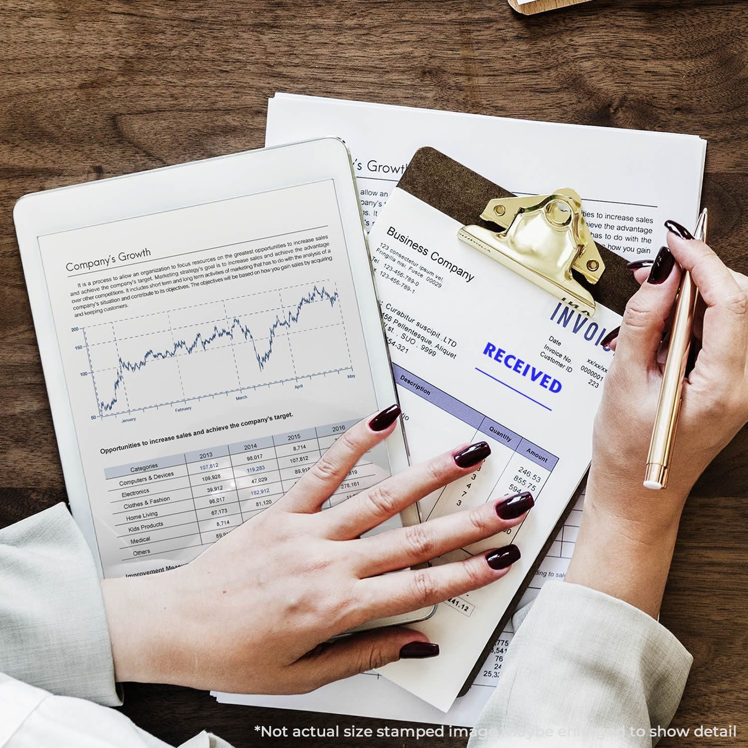 Business analytics desk with invoice received documents, growth chart on tablet, and hands holding a pen and clipboard.